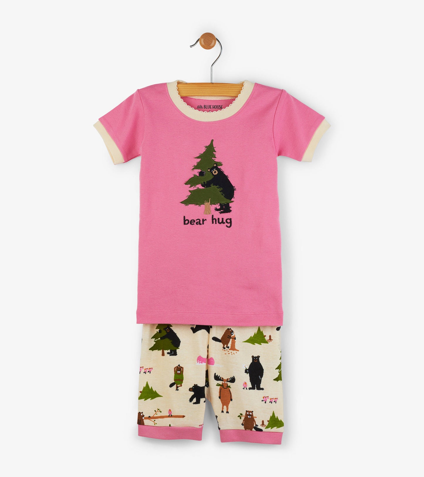 Pink short-sleeve pajama top with bear graphic, paired with cream shorts featuring forest animal print.