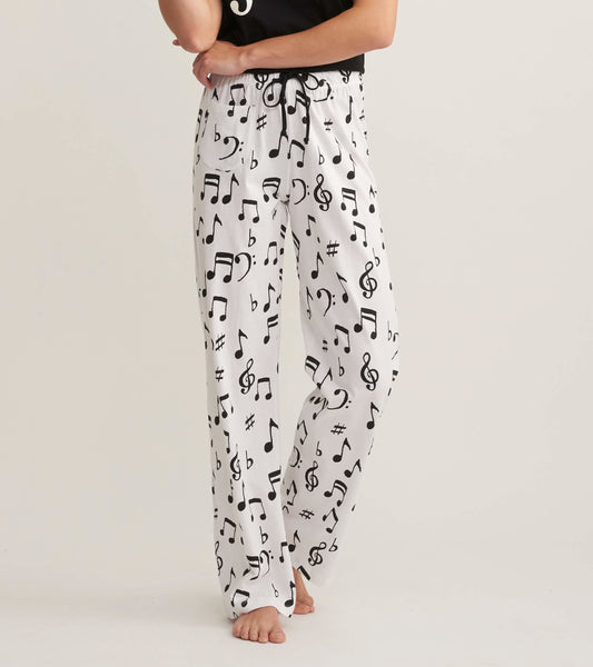 White cotton pajama pants featuring a black musical note pattern, with an elastic waistband and relaxed fit.