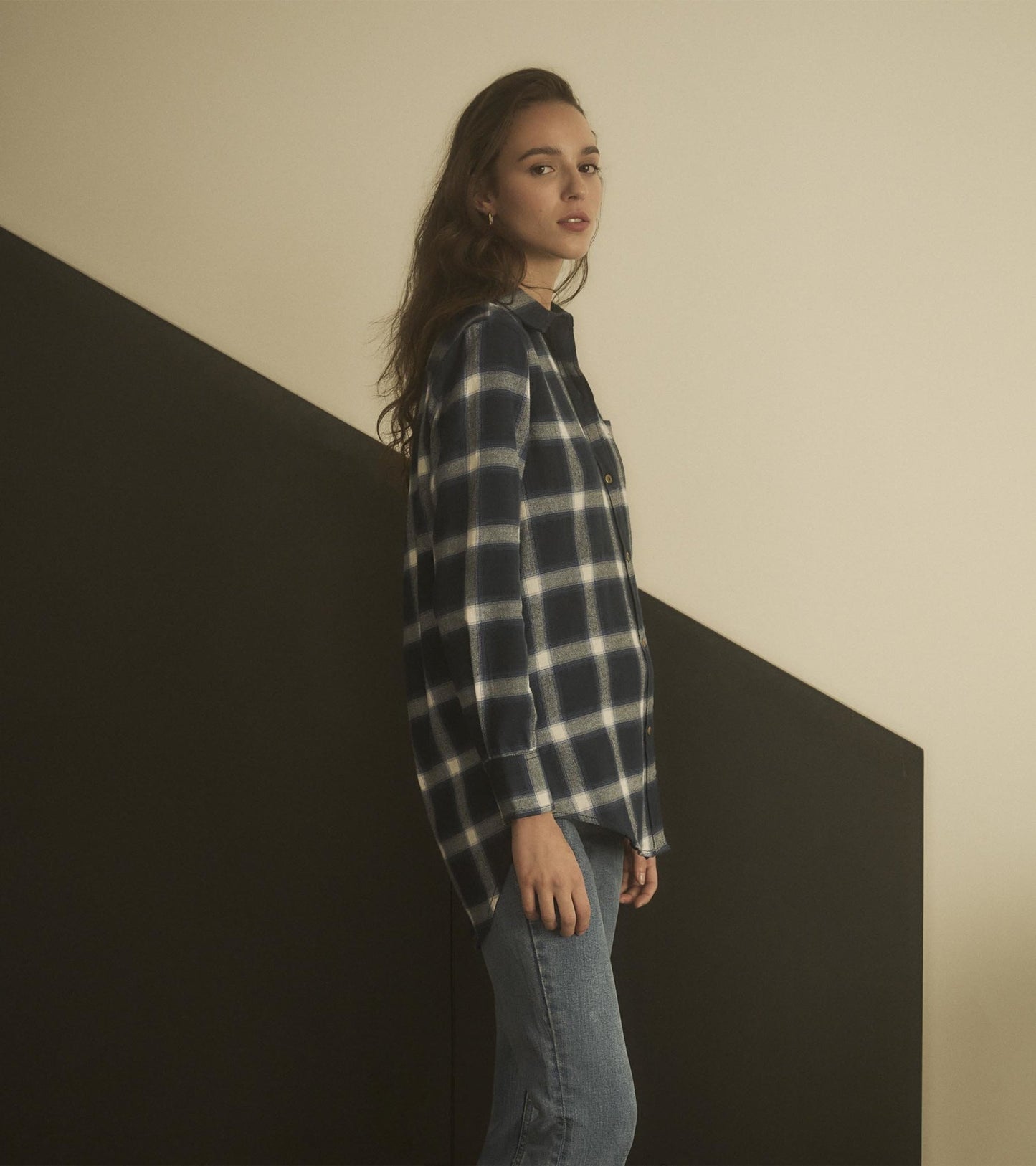 Navy and white checkered tunic with a relaxed fit, featuring a button-up front and side slits, styled with jeans.