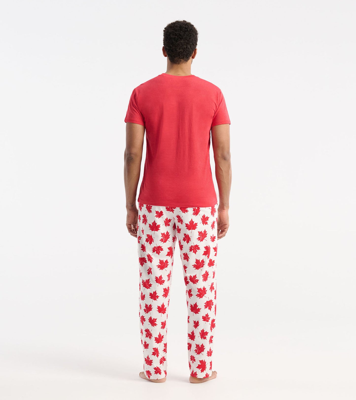 Red short-sleeve men's tee, viewed from the back, paired with white pants featuring red maple leaf patterns.