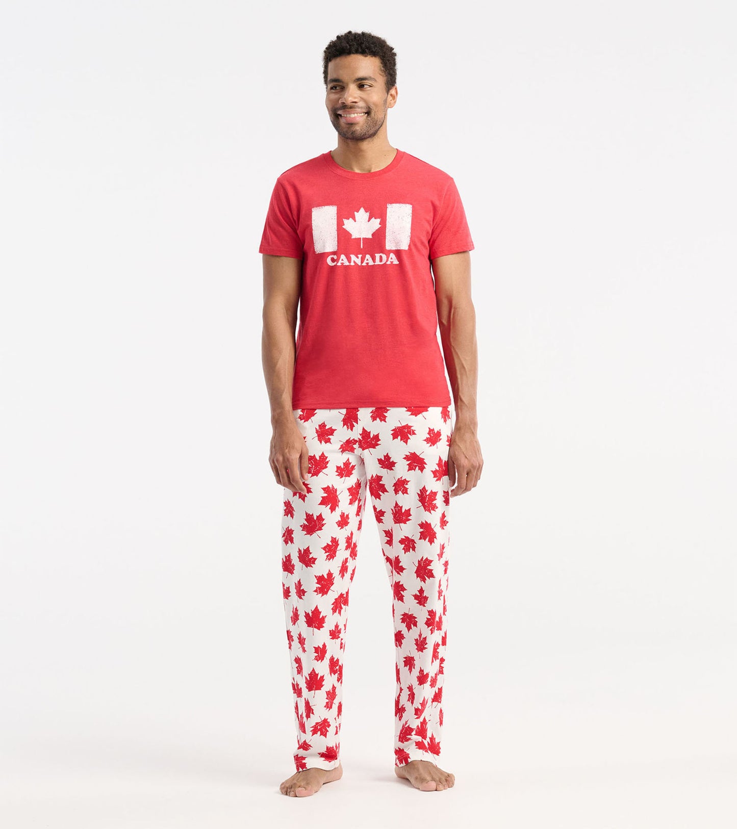 Red short-sleeve tee featuring a white Canada flag graphic, paired with white pants adorned with red maple leaf prints.