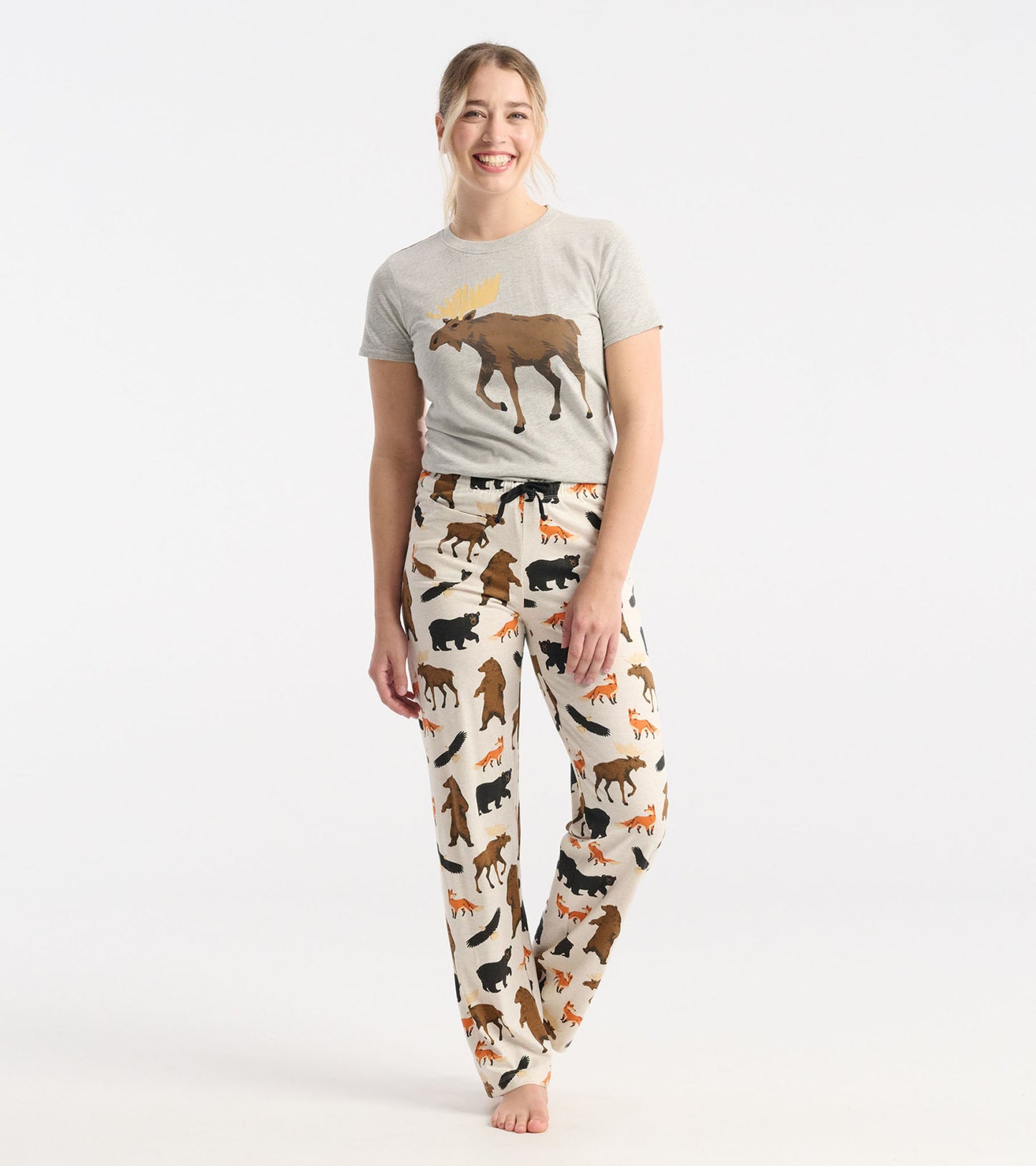Women's cotton blend pajama pants featuring a wildlife print with bears and foxes in earthy tones on a cream background.
