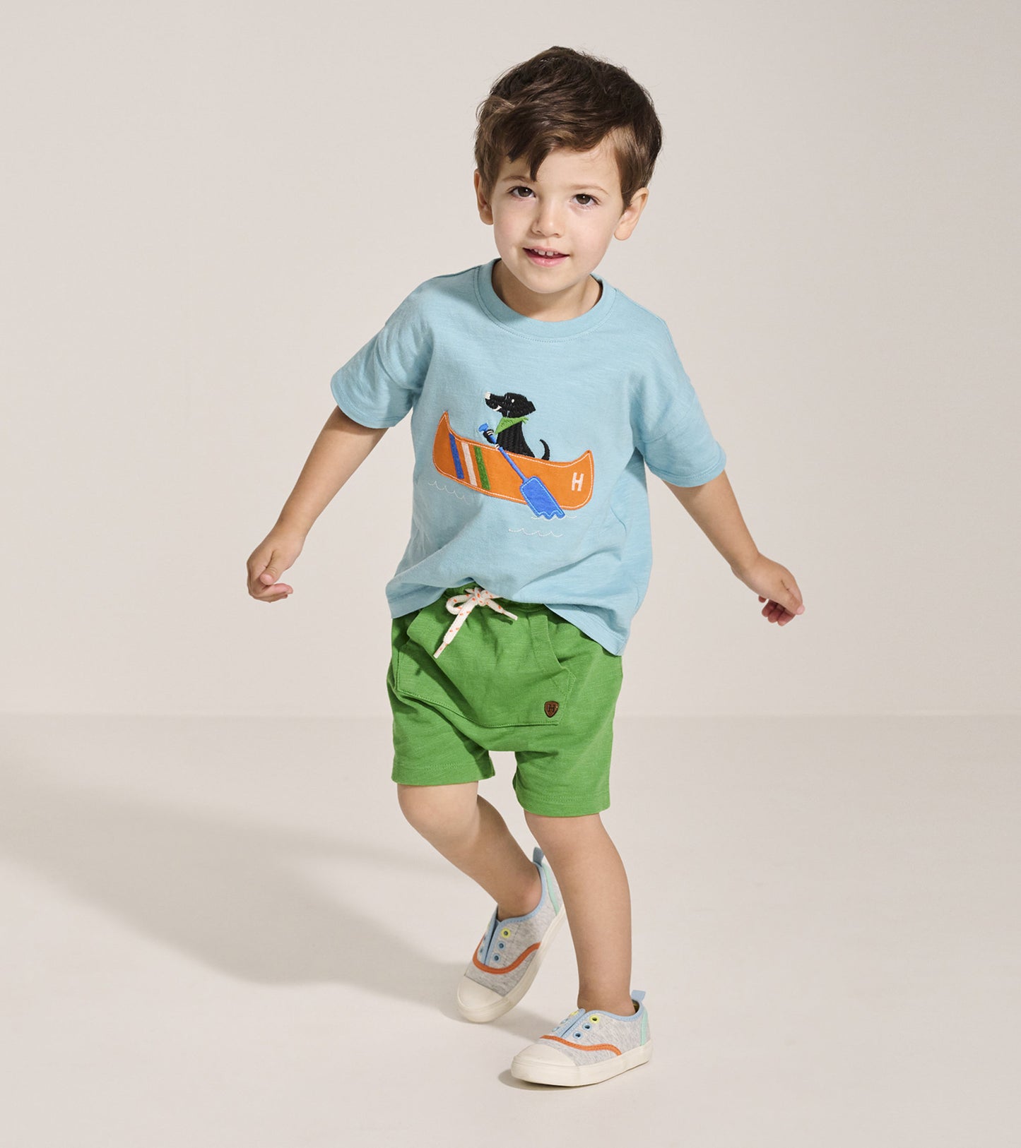Light blue graphic tee featuring a canoe and dog design, paired with green shorts, suitable for baby and toddler boys.