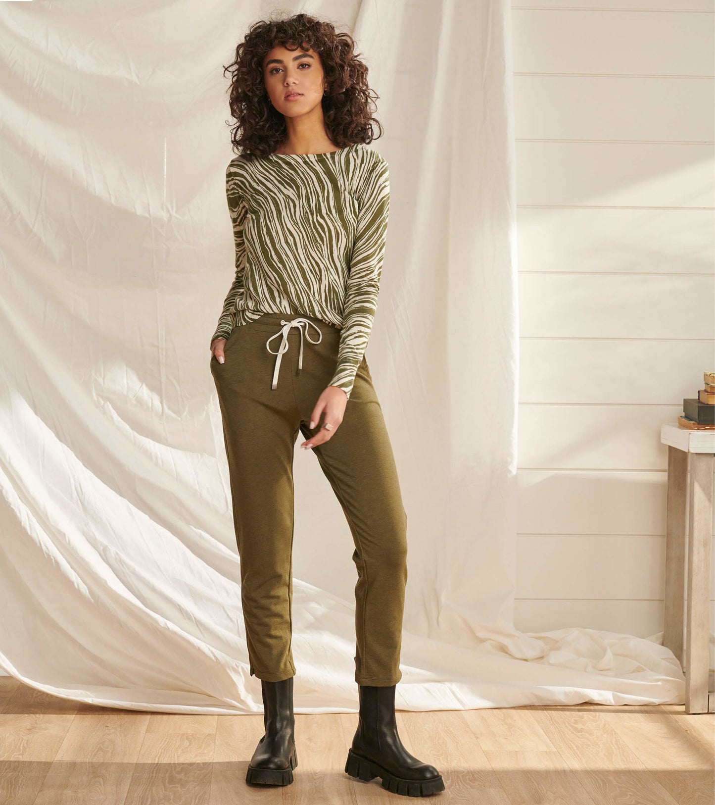 Loden green melange joggers with a tapered fit and drawstring waist, styled with a striped top and black boots.