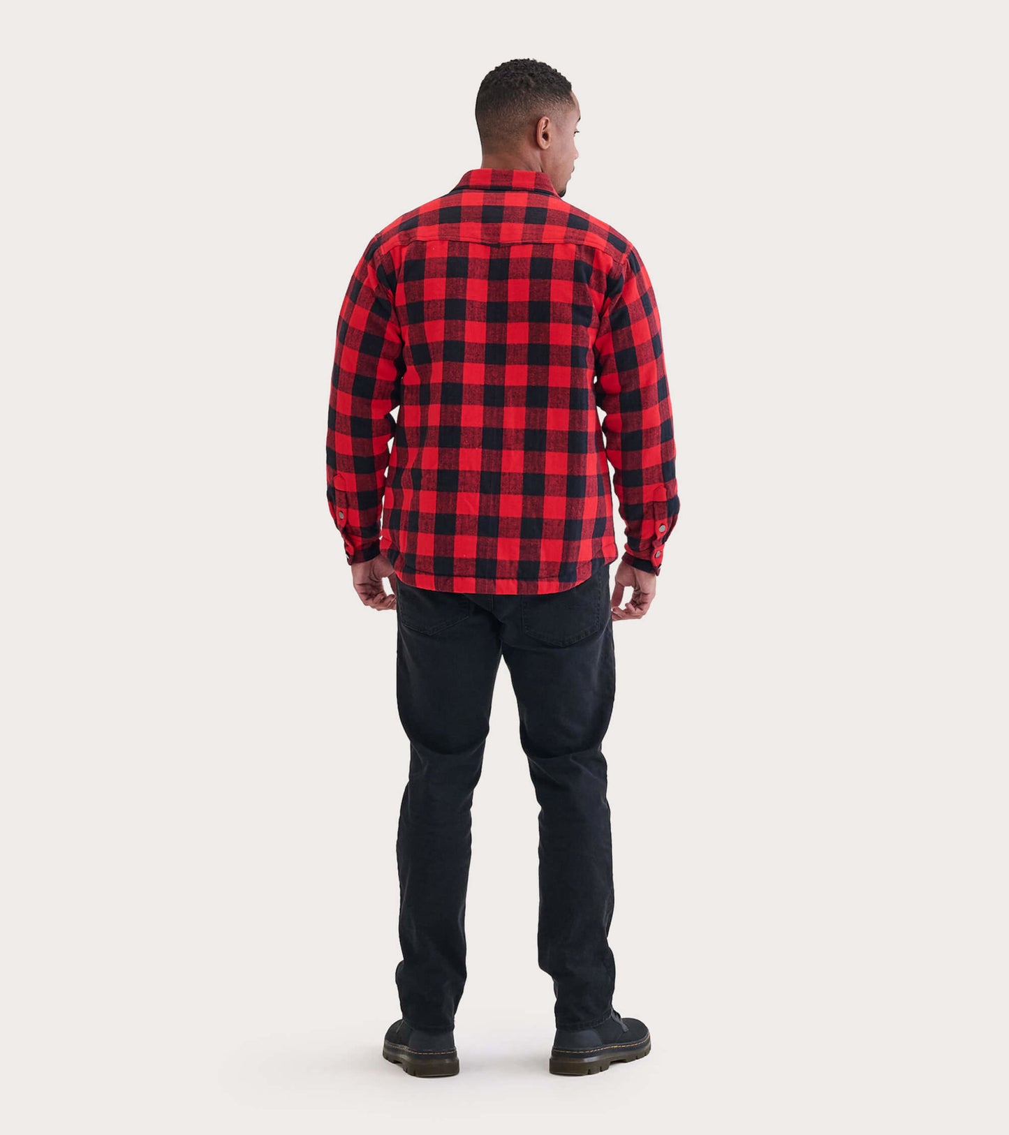 Men's quilted jacket in red and black buffalo plaid, featuring a button-up design and long sleeves, viewed from the back.