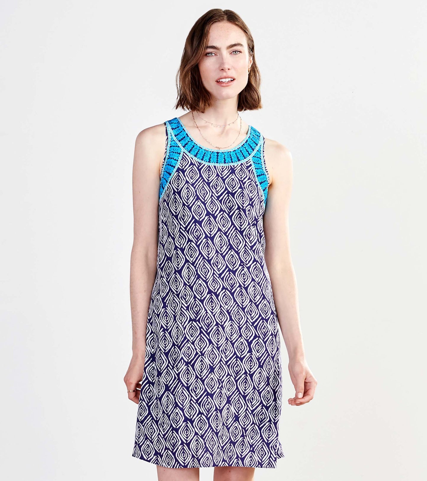Sleeveless dress featuring a blue patterned neckline and a geometric diamond print in purple and white.