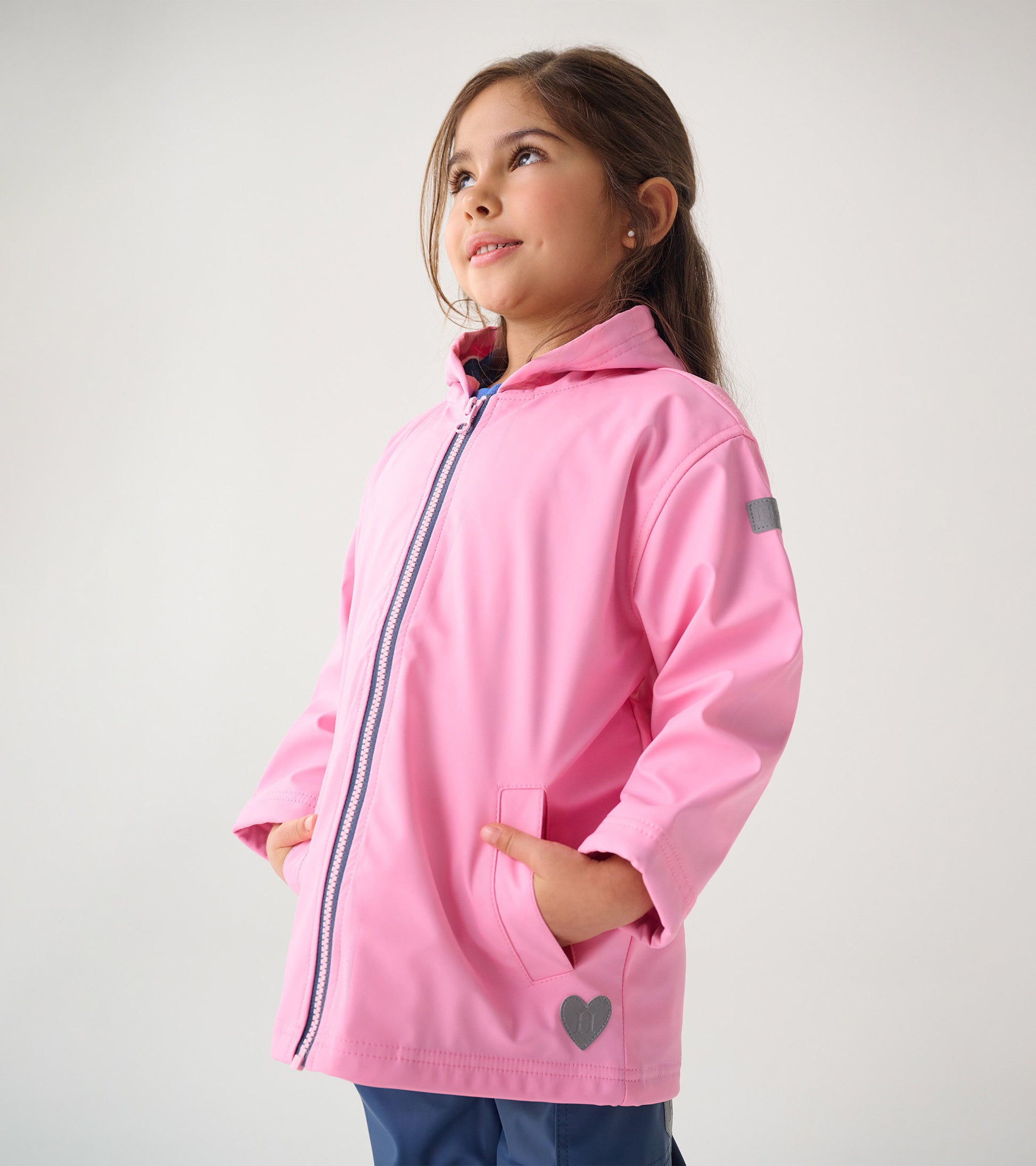 Classic pink zip-up rain jacket with a hood, featuring side pockets and a heart detail on the hem.