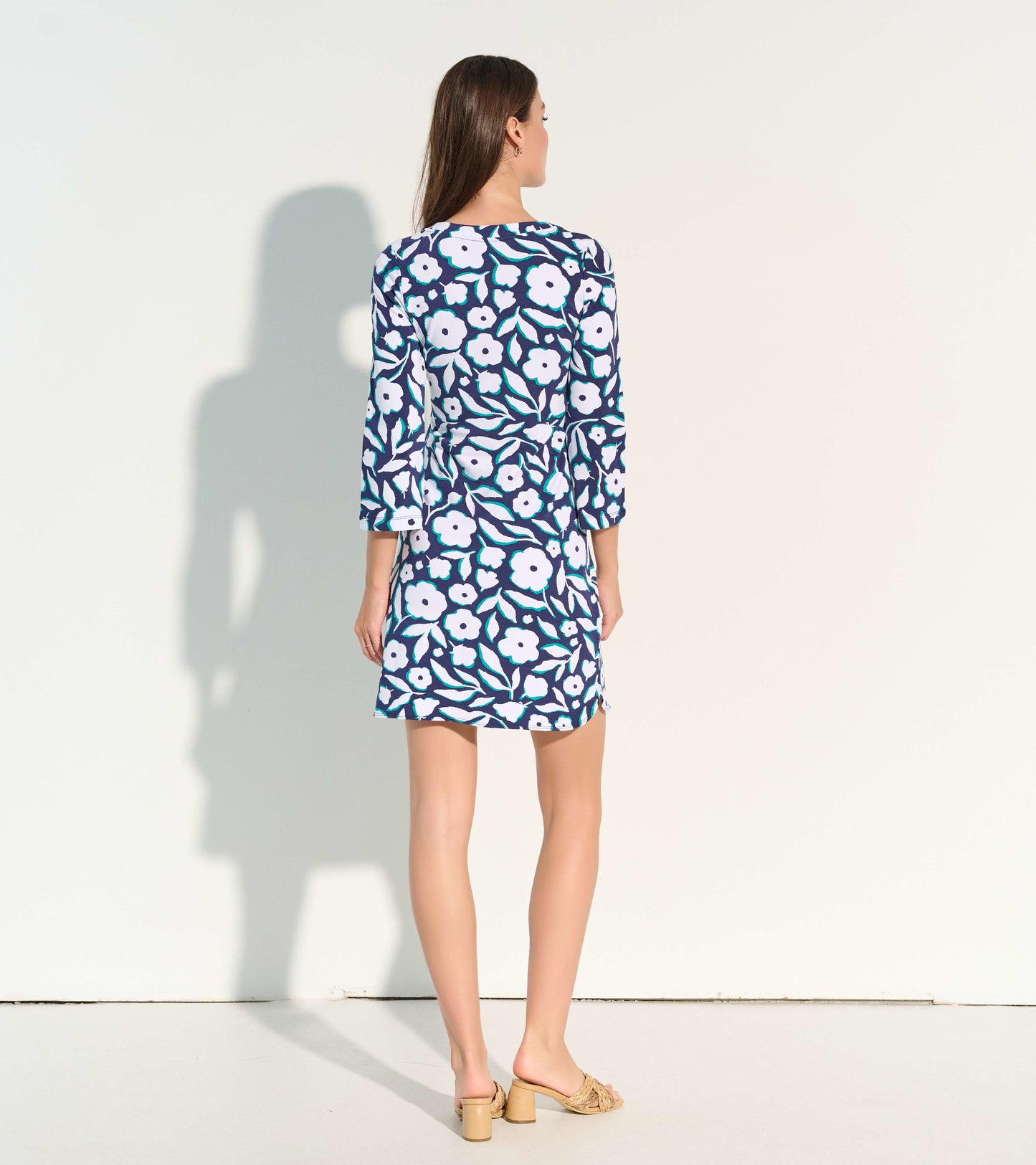 Navy dress with white floral pattern and three-quarter sleeves, shown from the back.