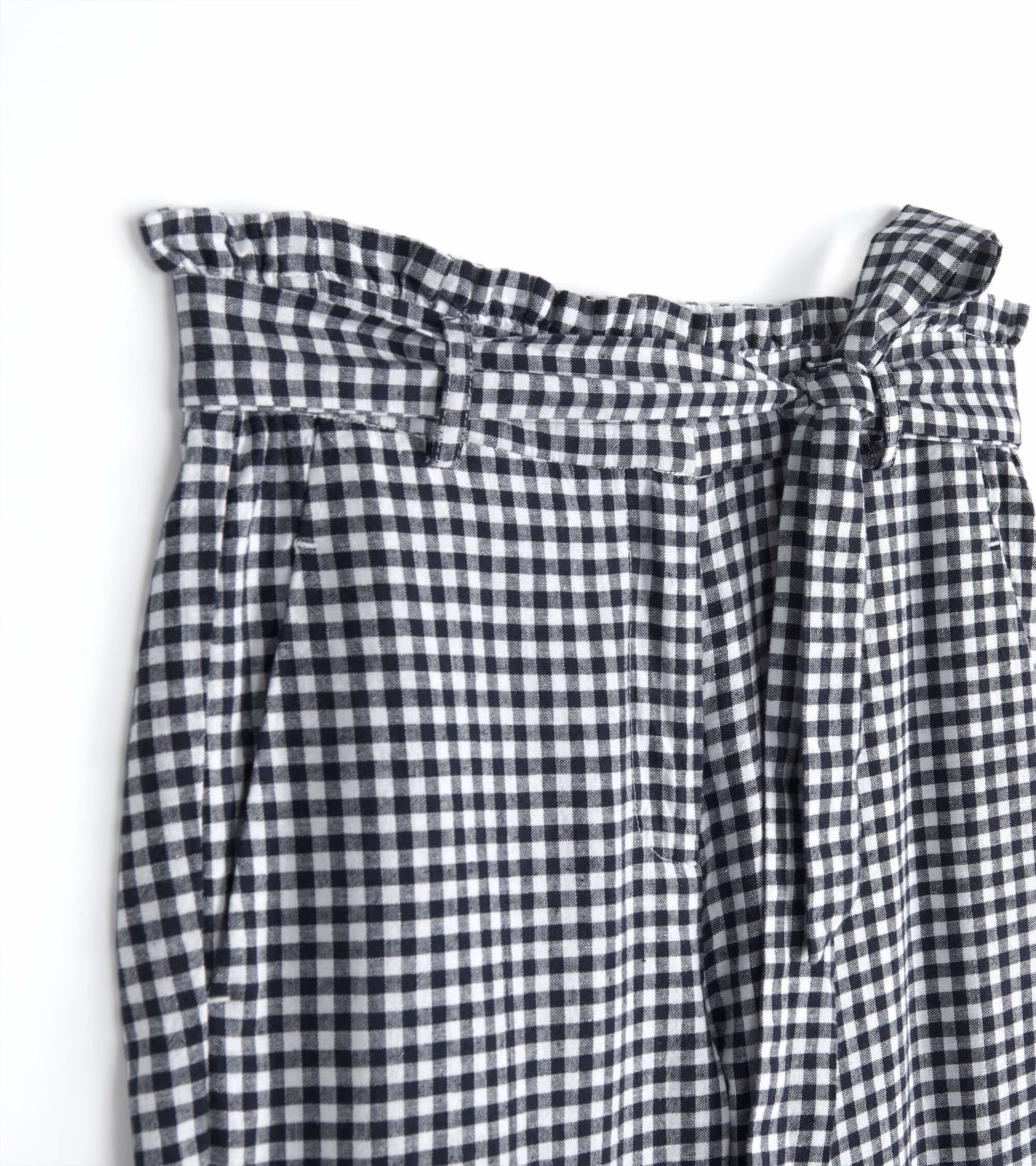 Navy gingham paper bag pants with a ruffled waistband and tie detail, featuring pleats for a relaxed fit.