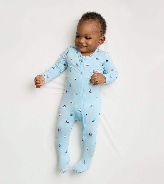 Light blue footed sleeper featuring a sailboat pattern, designed for baby boys, with a front zipper for easy dressing.