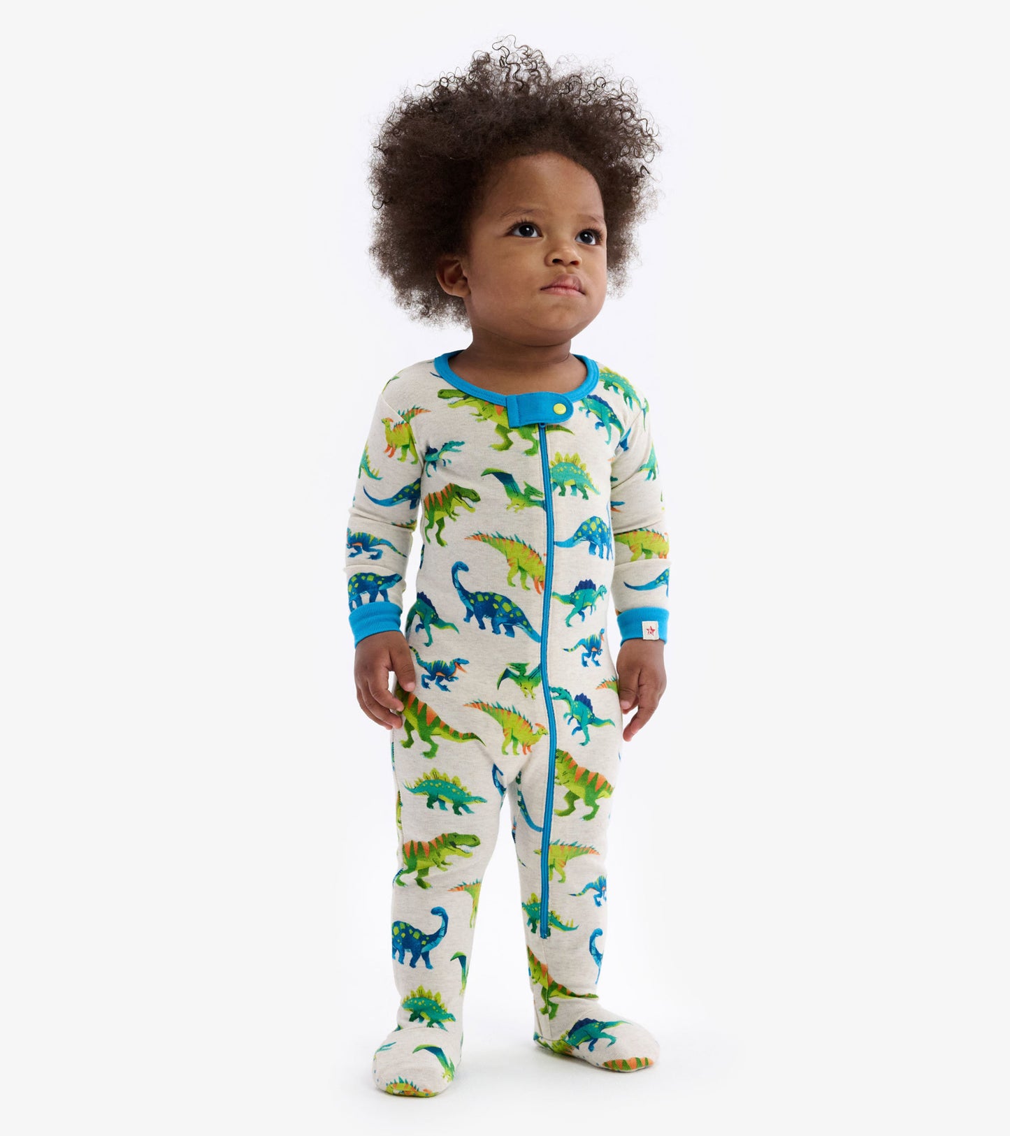 Colourful dinosaur print footed sleeper with blue trim, designed for infants, featuring a front snap closure.