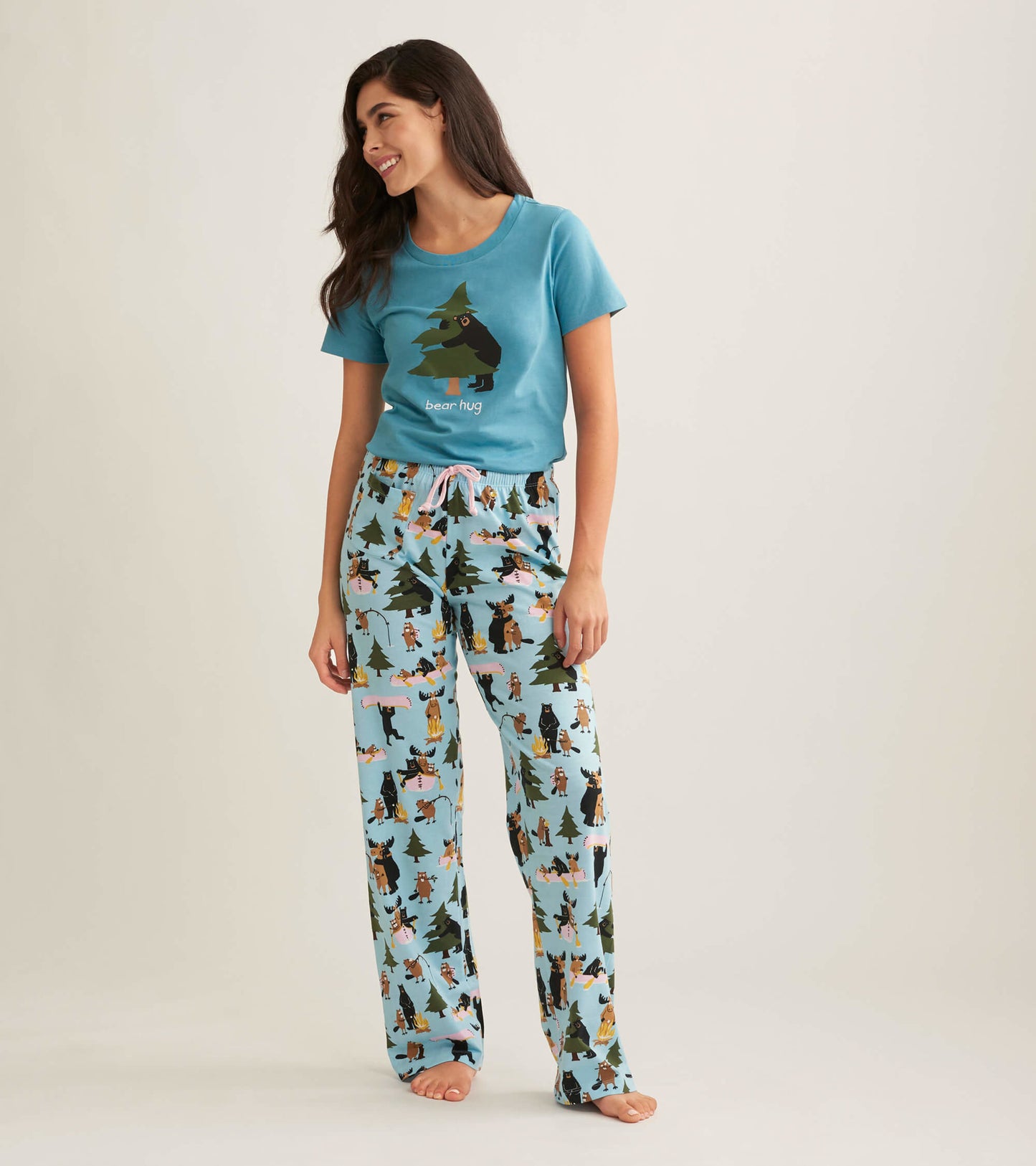 Light blue pajama t-shirt featuring a bear graphic, paired with patterned pants depicting animals and trees.