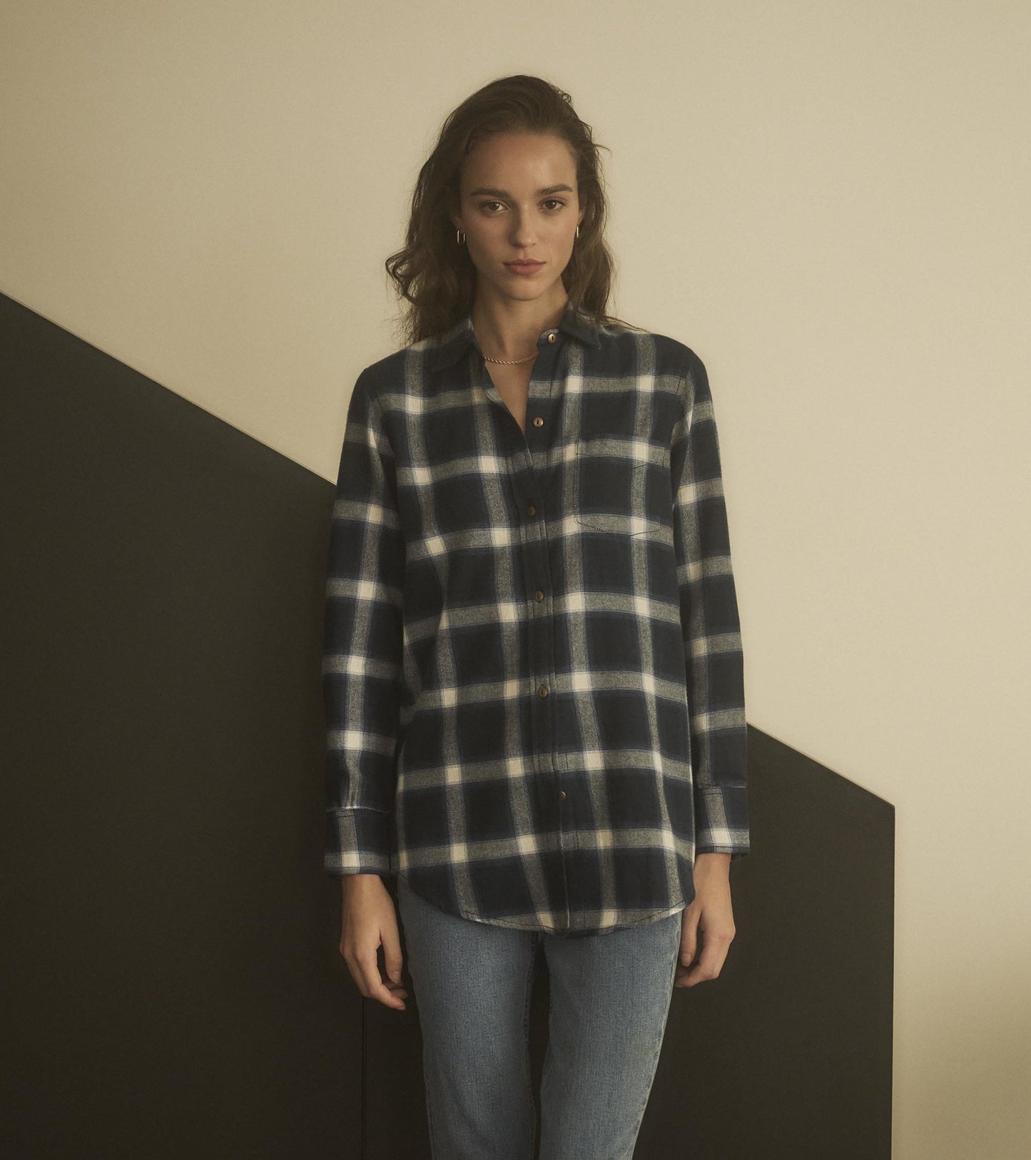 Navy and white plaid tunic with a button-up front and long sleeves, styled with jeans.