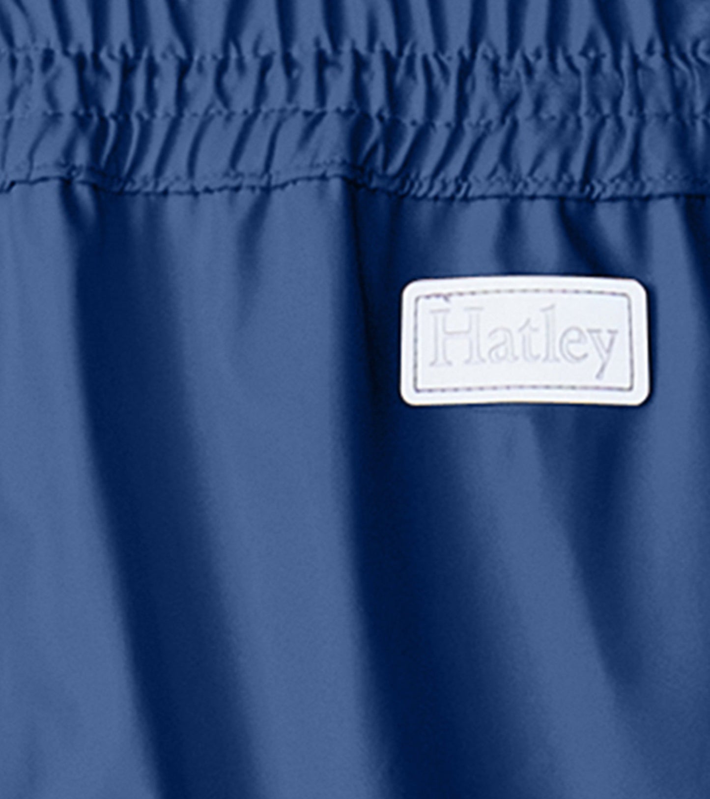 Navy blue kids' rain pants with an elastic waistband and a smooth, waterproof material.