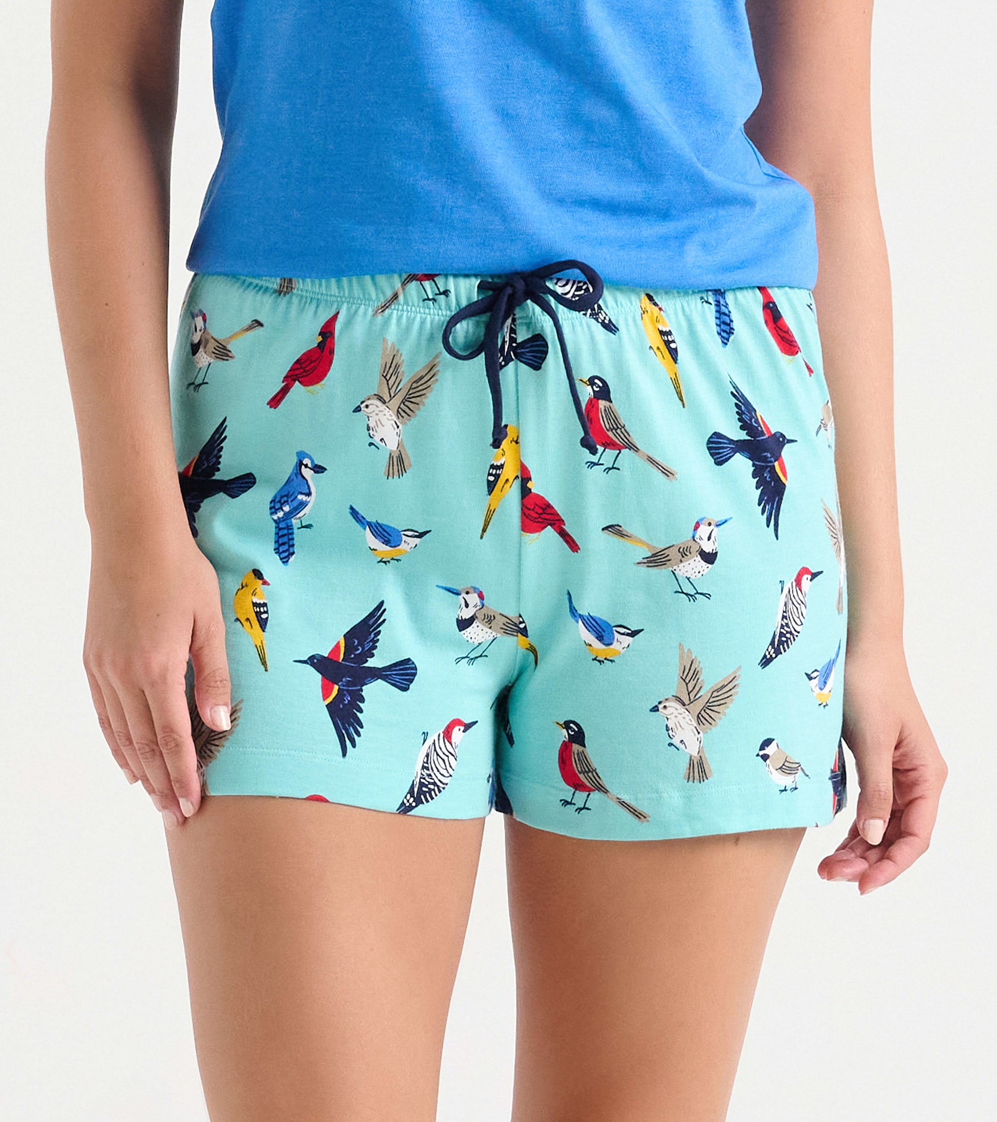 Light blue cotton sleep shorts featuring a colorful bird print, with an elastic waistband and drawstring detail.