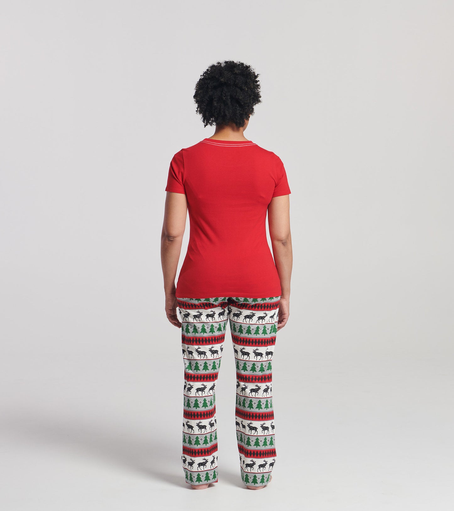 Red short sleeve t-shirt paired with patterned pajama pants featuring reindeer and trees, viewed from the back.