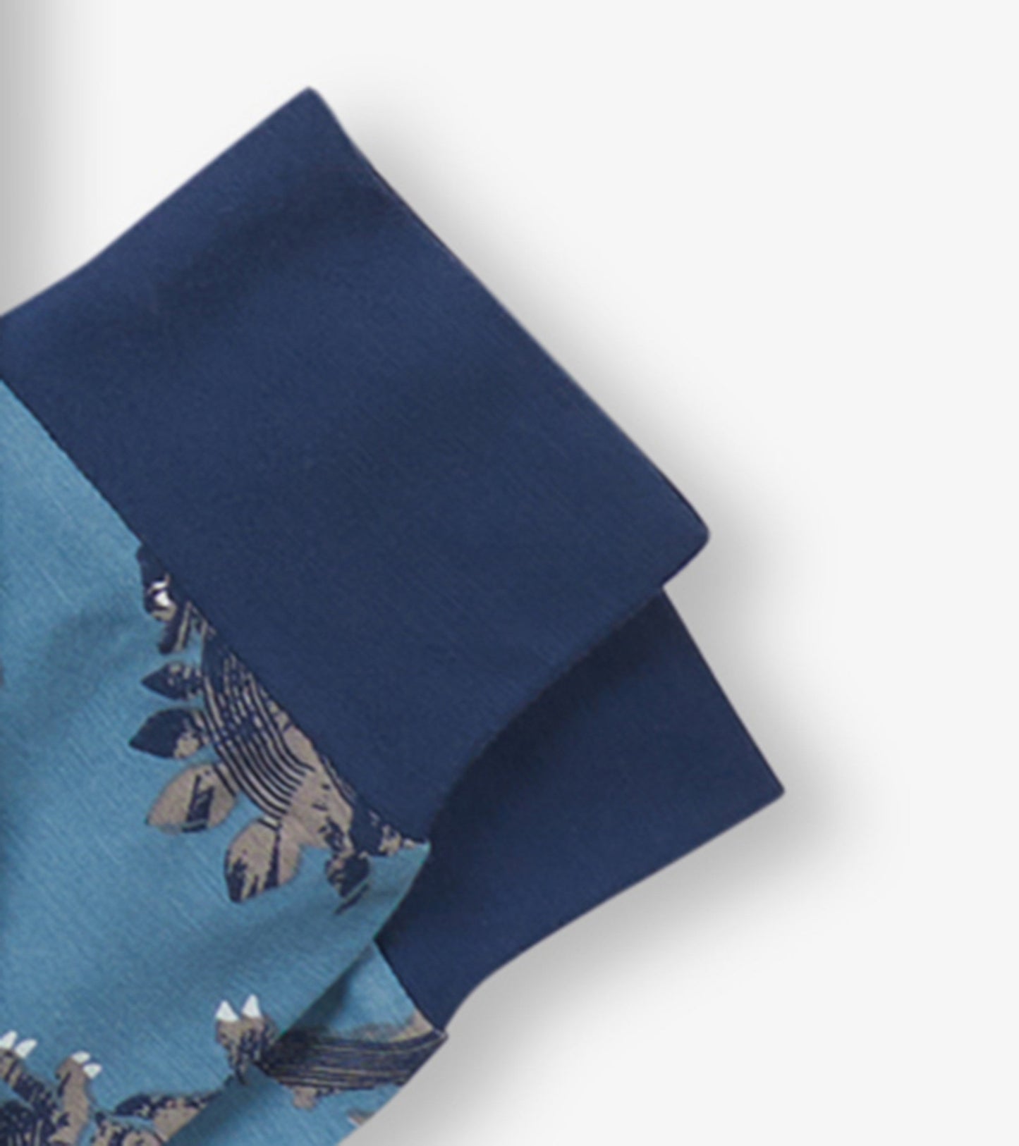 Boys' bamboo pajama set featuring a blue base with dinosaur prints and navy cuffs. Soft and comfortable for sleepwear.