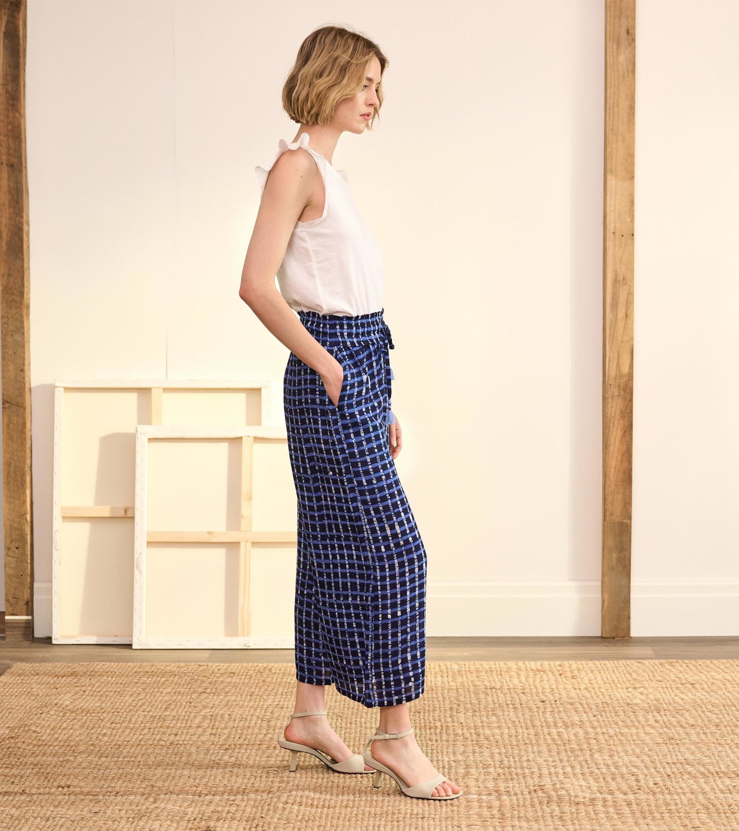 Navy plaid pants with a relaxed fit, featuring a drawstring waist and side pockets, styled with a white top.