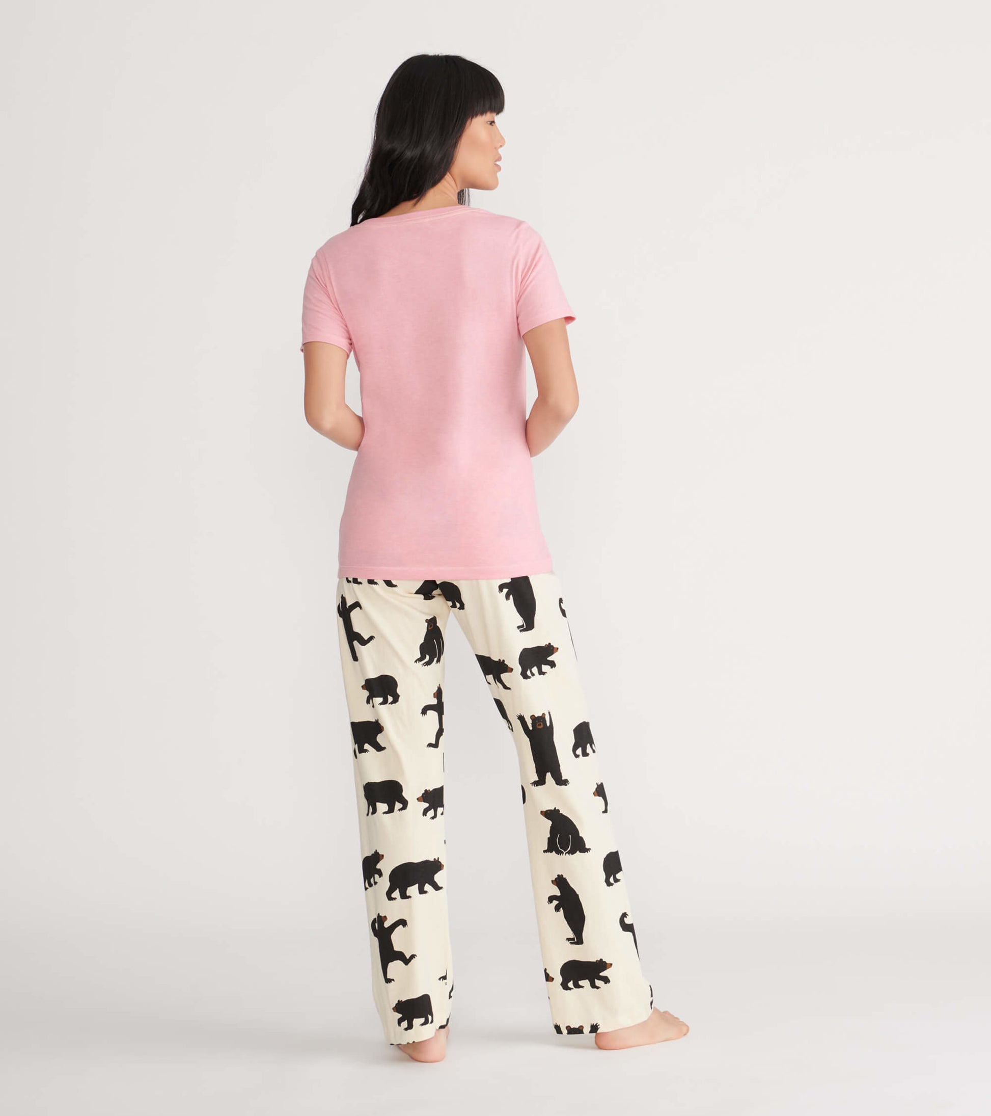 Pink short-sleeve pajama t-shirt paired with cream pants featuring black bear silhouettes.
