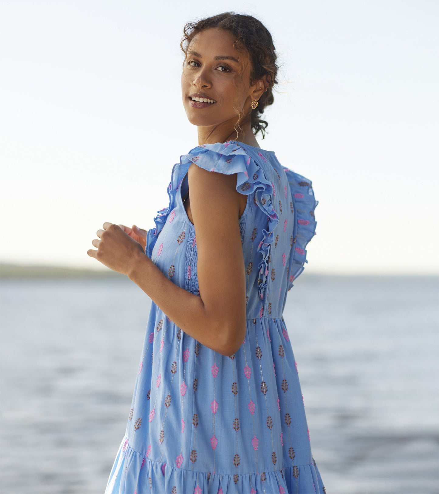 Light blue midi dress with ruffled sleeves and a feather pattern in pink and brown, perfect for casual summer outings.
