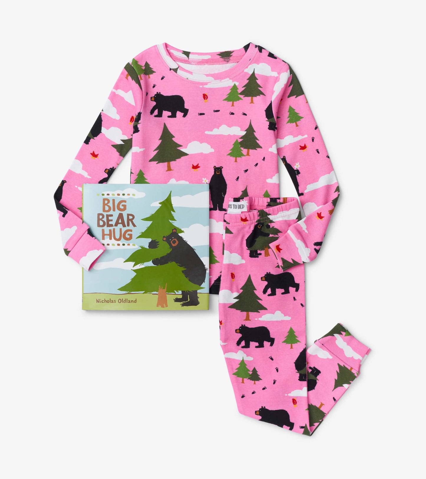 Pink pajama set featuring bear and tree patterns, paired with the "Big Bear Hug" children's book.