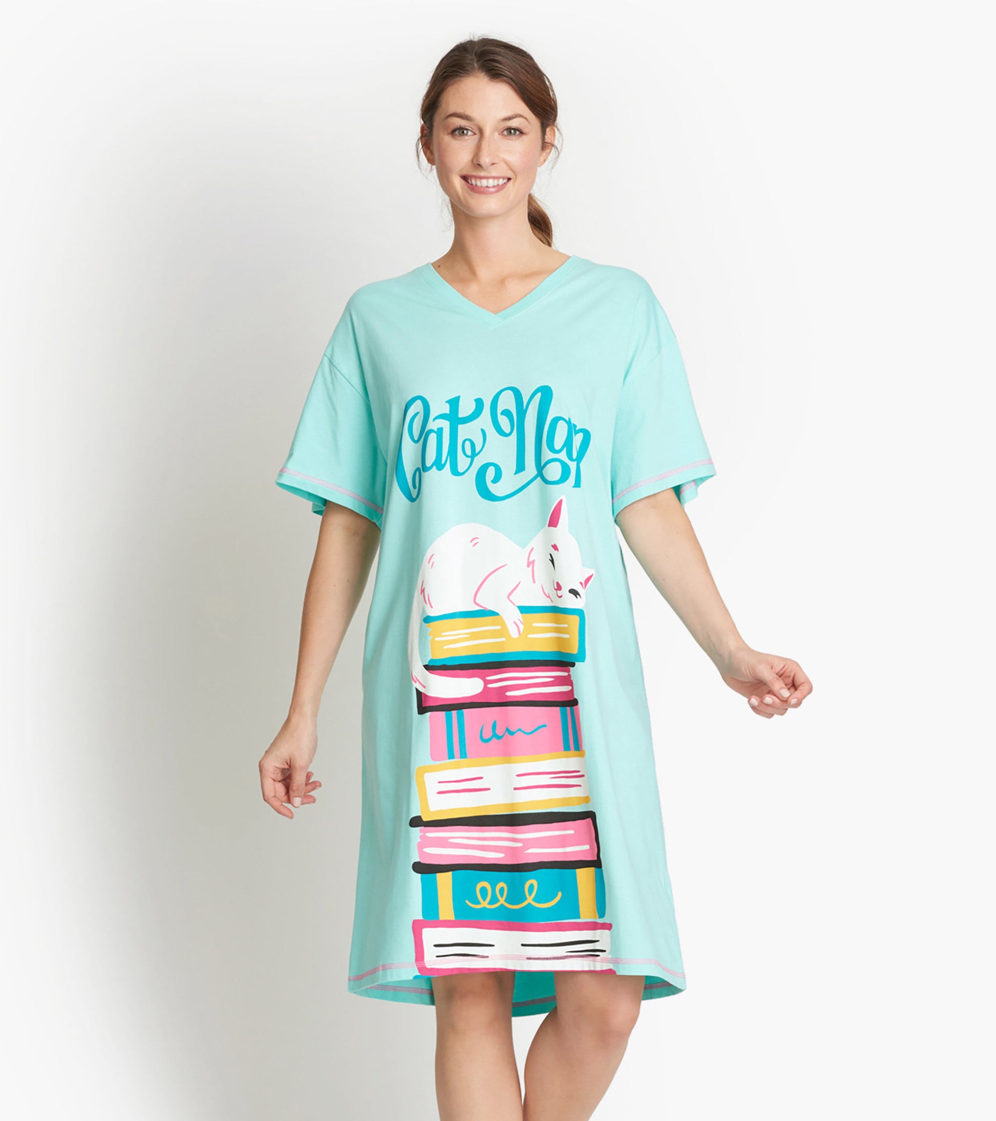 Light blue sleepshirt featuring a playful cat illustration resting on colorful stacked books, with a V-neck and short sleeve…