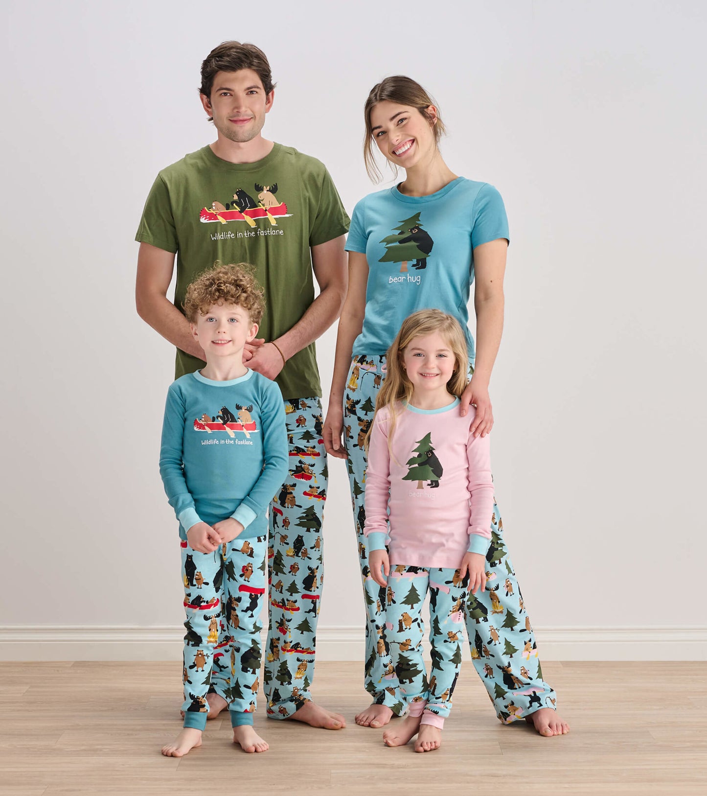 Pink kids' pajama set with tree appliqué, featuring playful wildlife patterns on light blue pants.