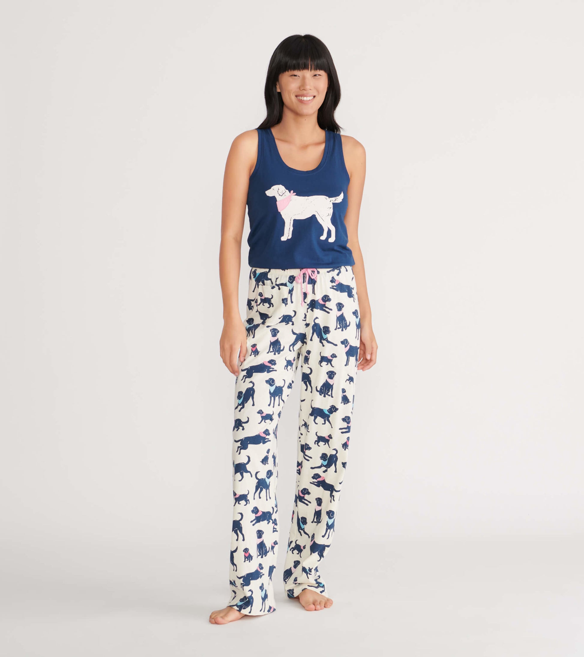 Navy tank top with dog graphic paired with cream pajama pants featuring a playful dog print and pink drawstring.