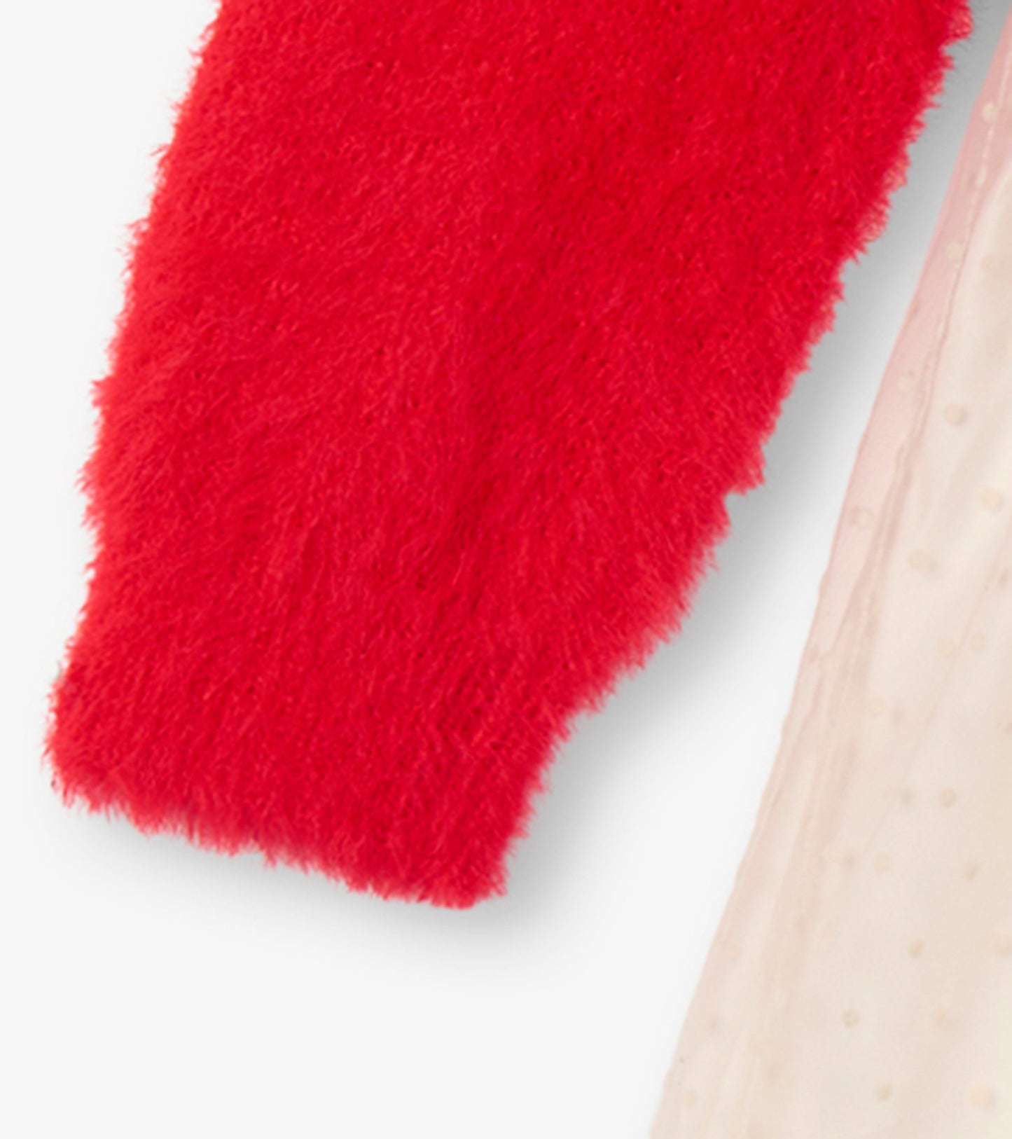 Red fuzzy sleeve detail paired with a light, textured fabric, showcasing a playful mix of materials for a holiday dress.