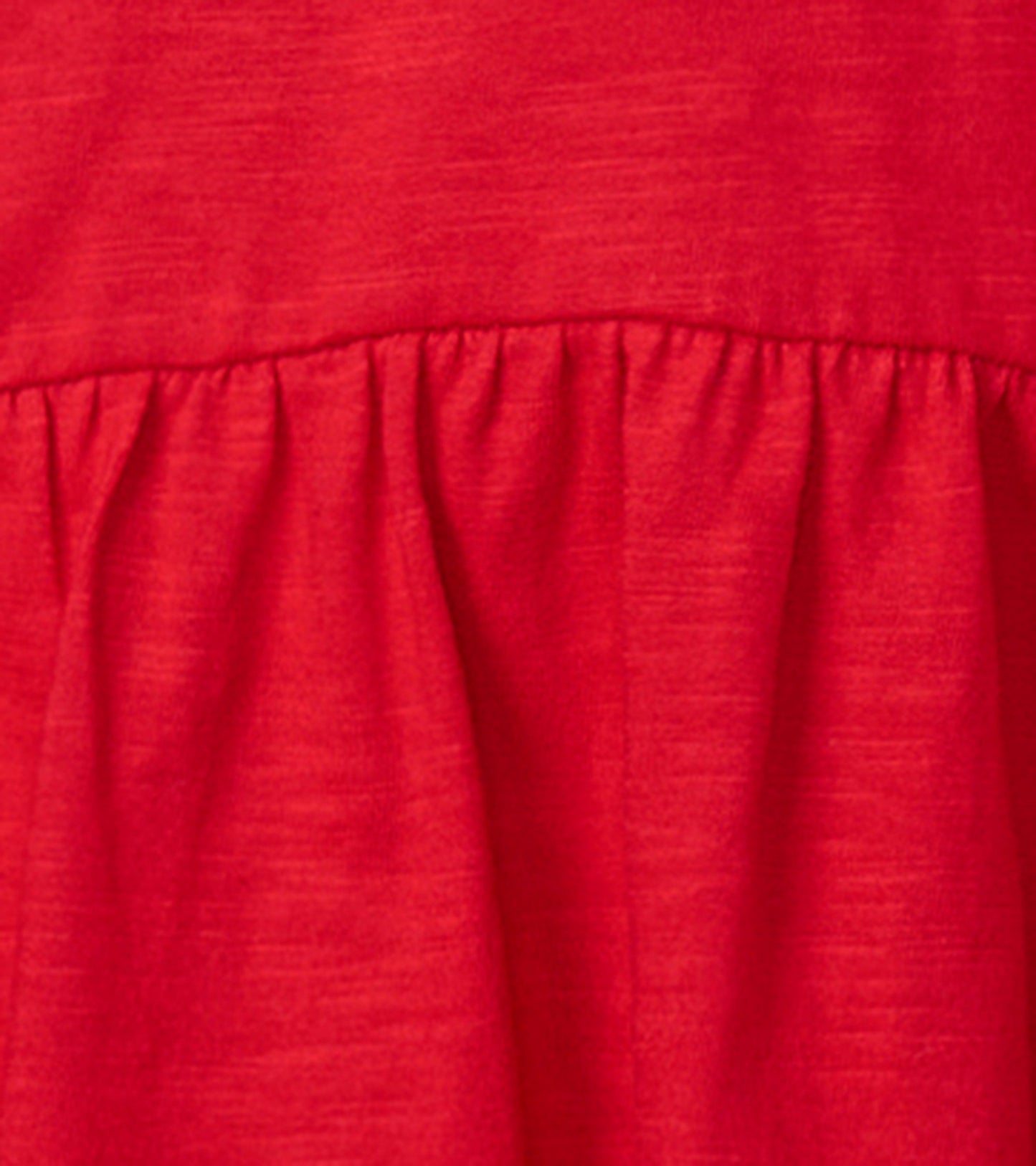 Red holiday party dress featuring a gathered waist and soft fabric, perfect for festive occasions.
