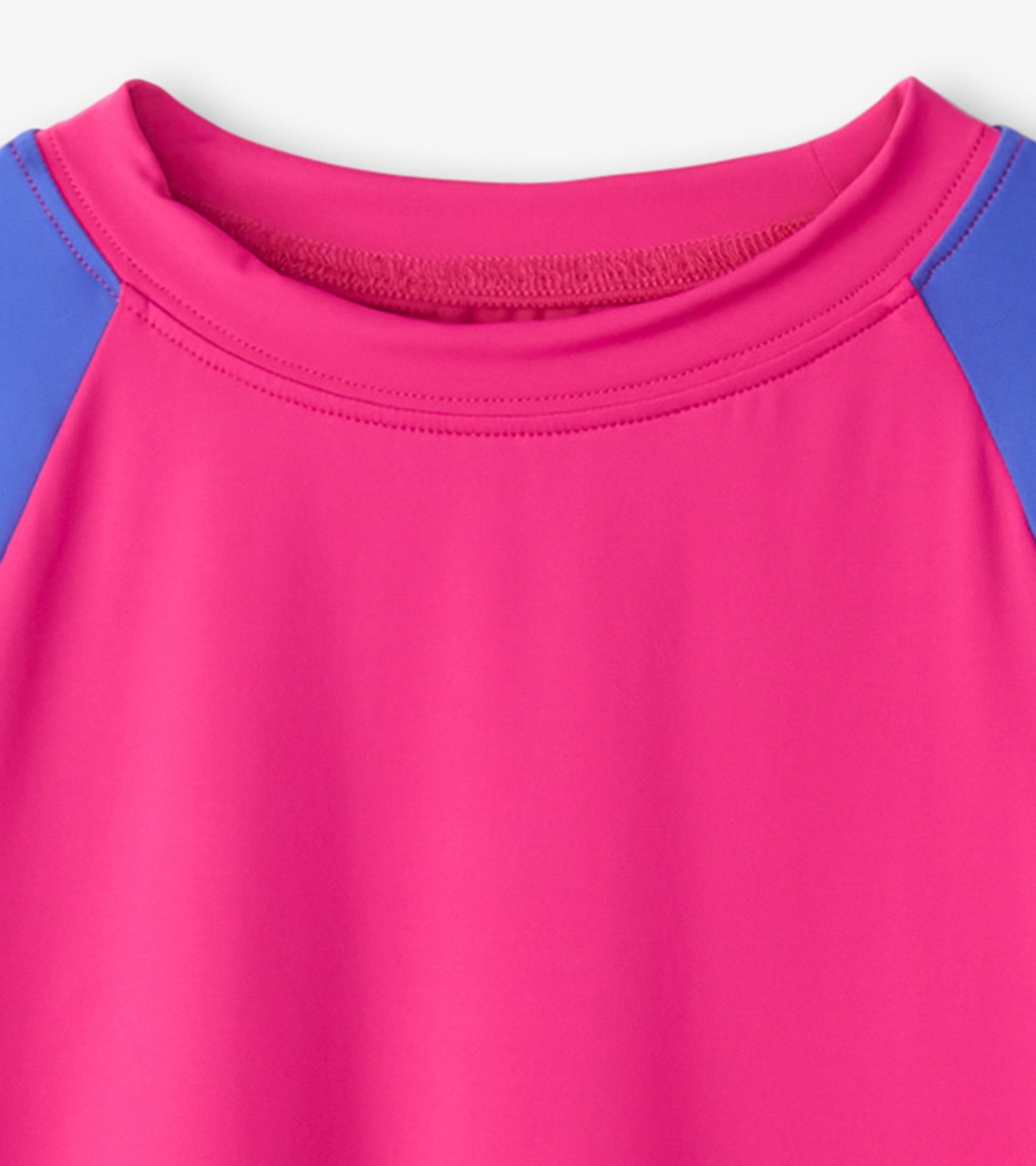 Fuschia purple long sleeve rashguard with blue accents, featuring a round neckline and smooth, stretchy fabric.