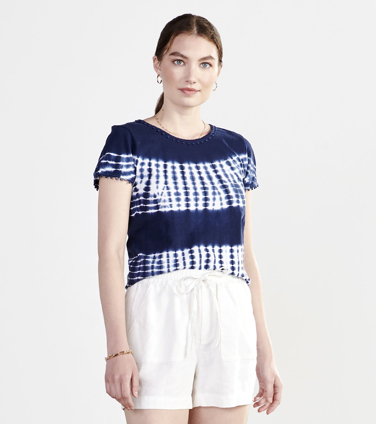 Navy blue tie-dye tee with short sleeves and a round neckline, paired with white shorts.