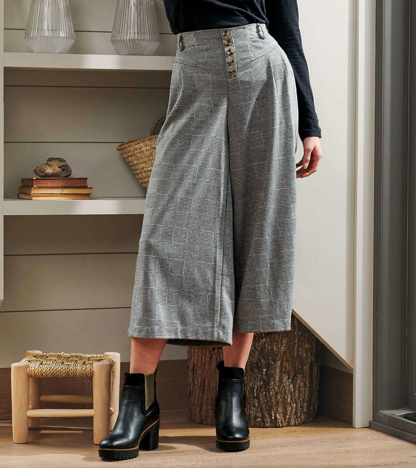 Wide leg houndstooth pants with high waist and button detail, styled with black ankle boots.