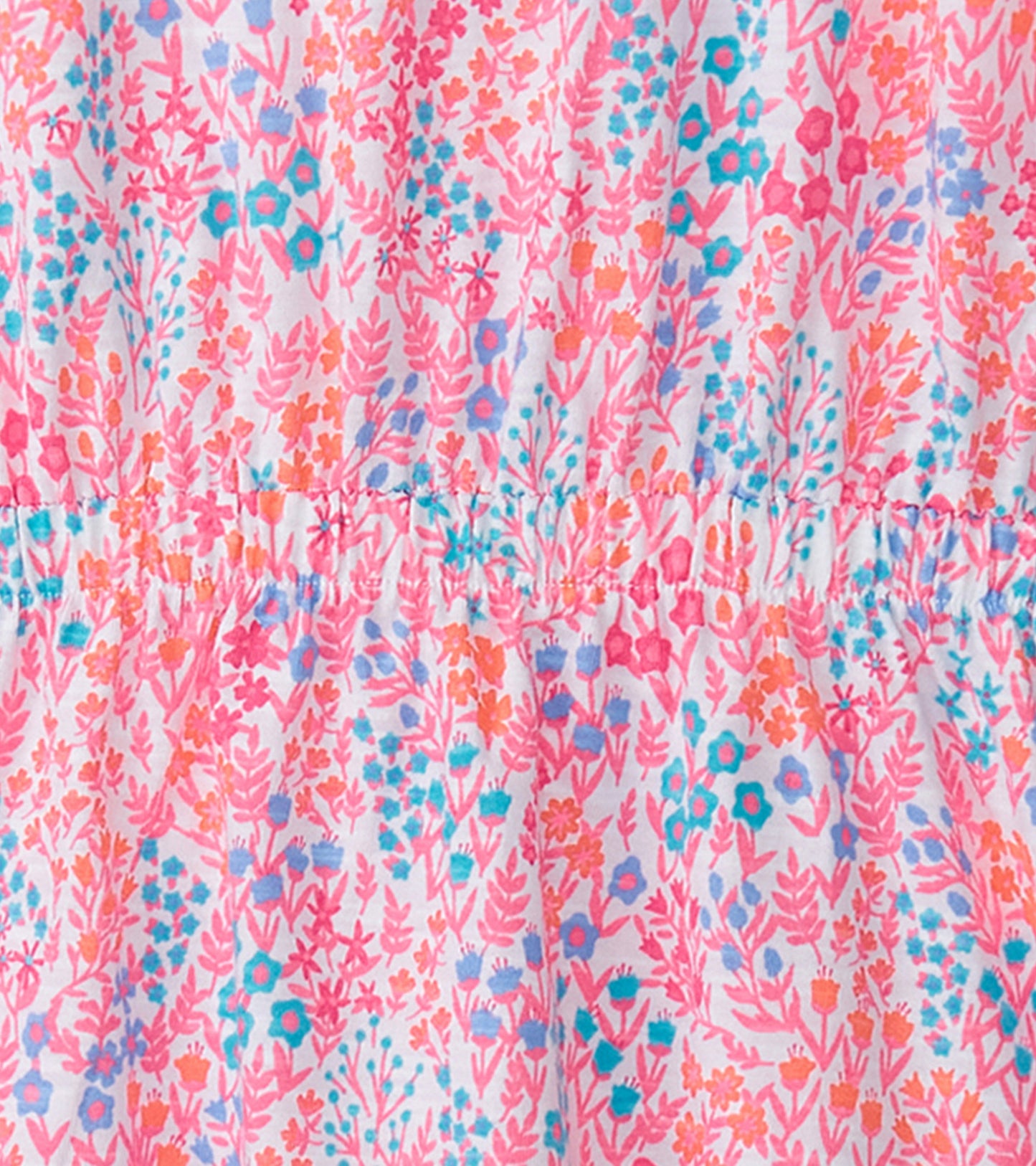 Pink dress featuring a vibrant floral pattern with shades of blue and orange, designed for a relaxed fit.