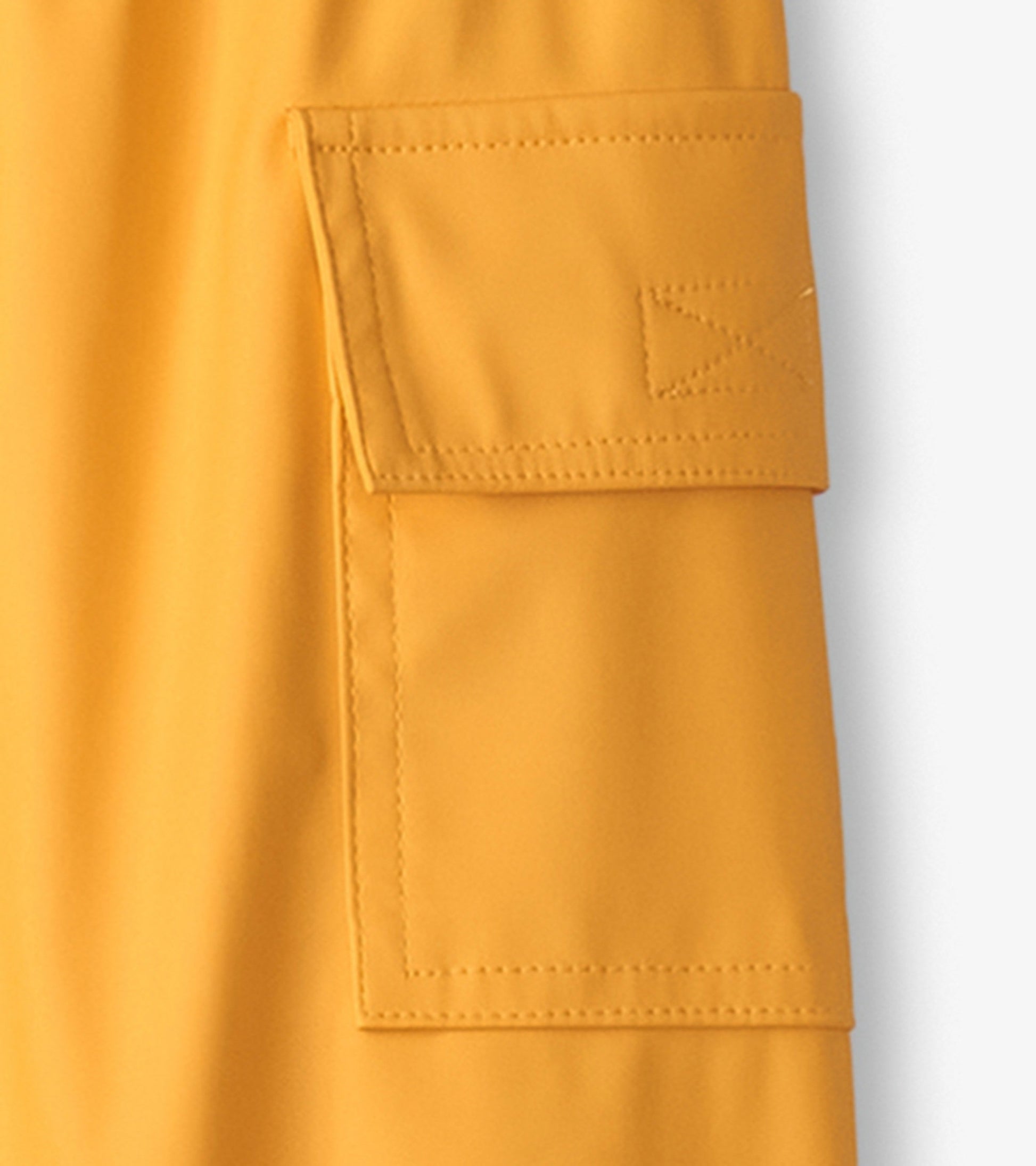 Yellow waterproof kids' rain pants featuring a side pocket and elastic waistband for comfort.
