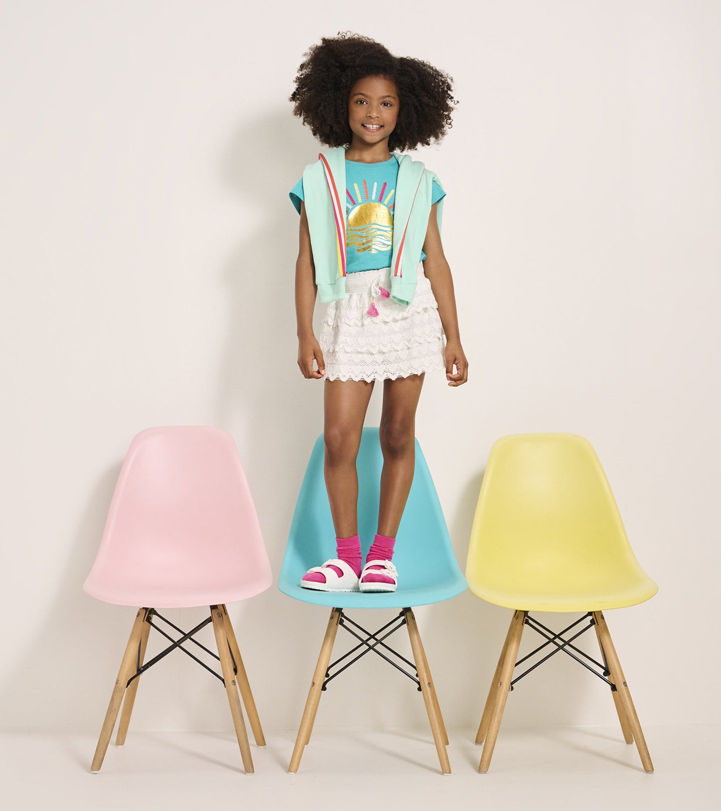 White skort with heart pattern, layered design, worn by a girl standing on colorful chairs, paired with a graphic tee.