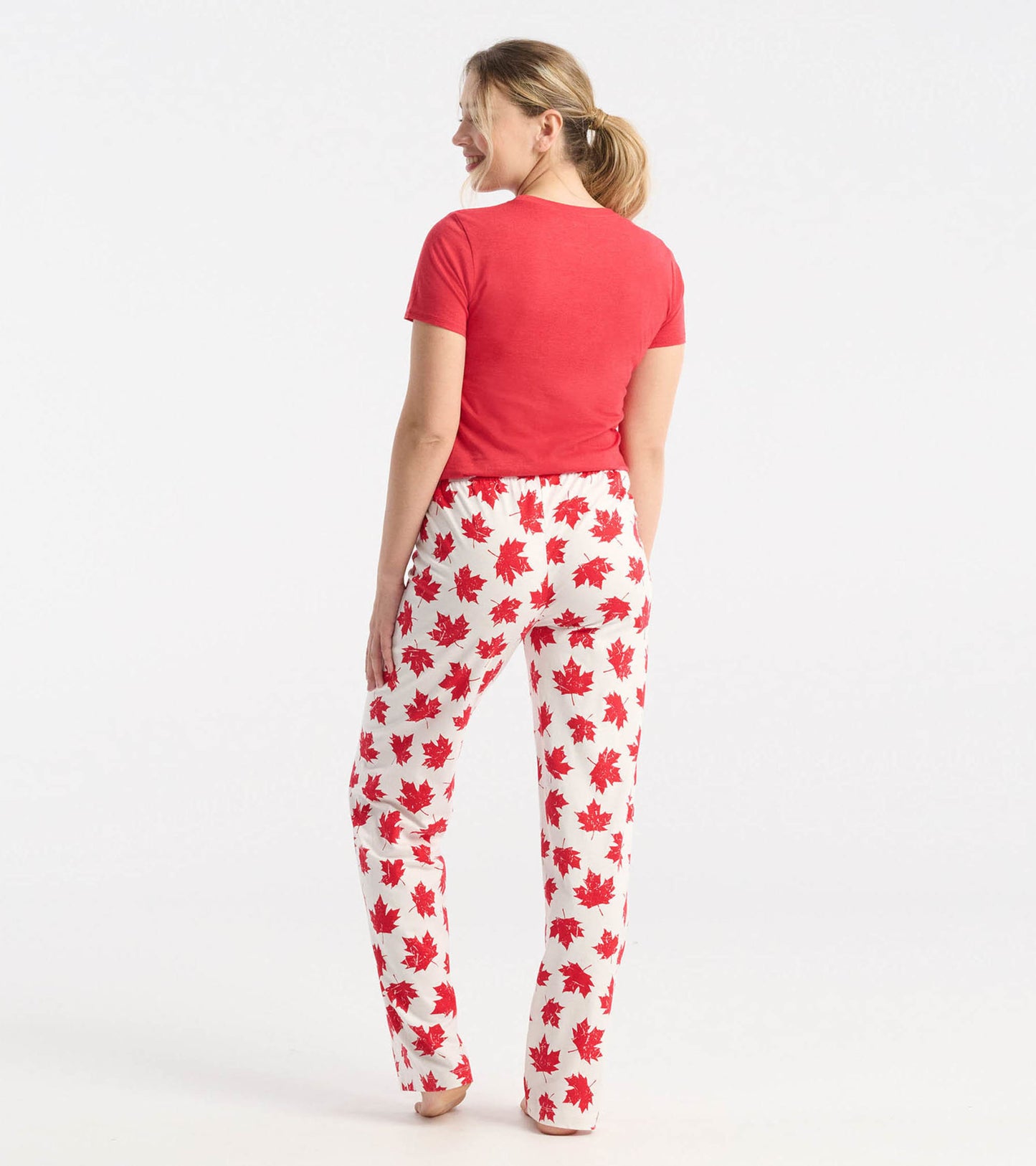 Red and white cotton pajama pants featuring a maple leaf pattern, shown from the back.