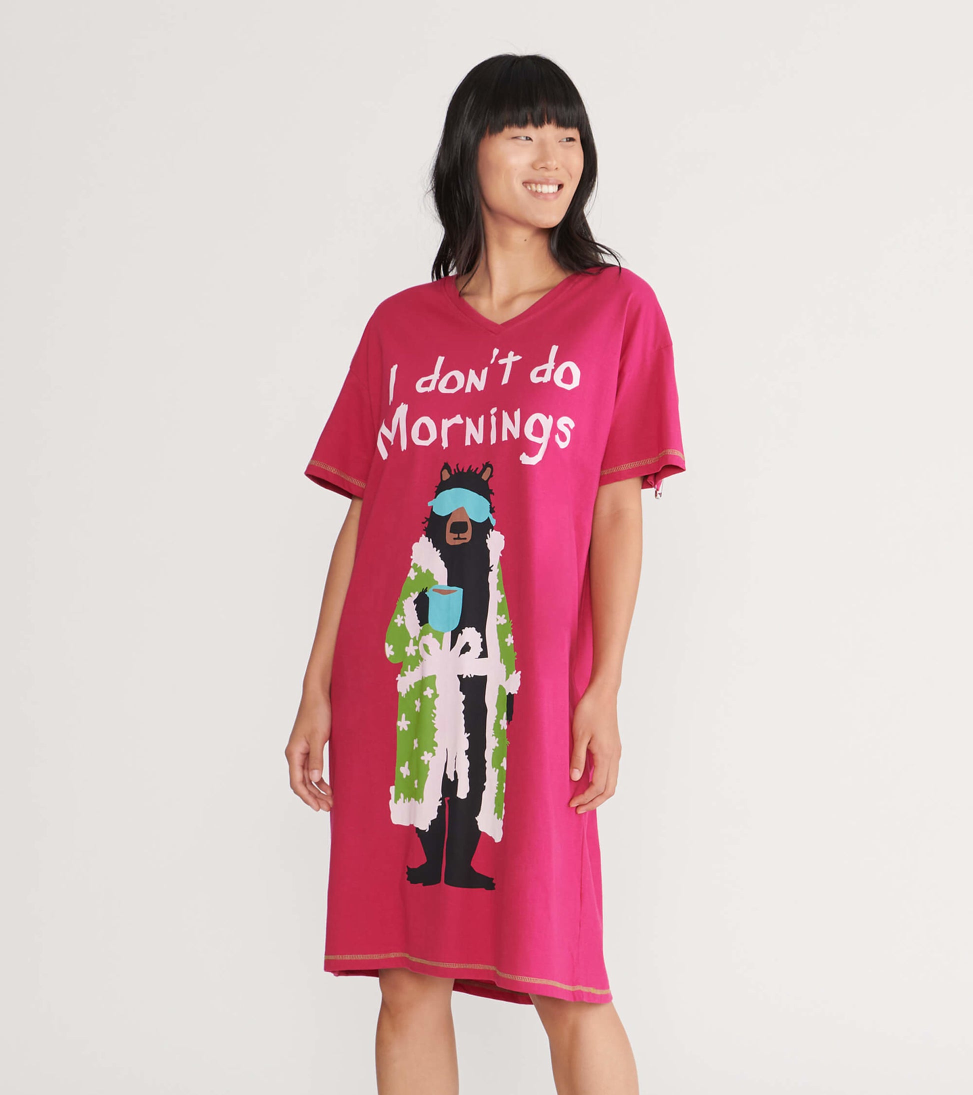Pink women's sleepshirt featuring a bear graphic in a robe with the text "I don't do Mornings." Short sleeves and relaxed fi…