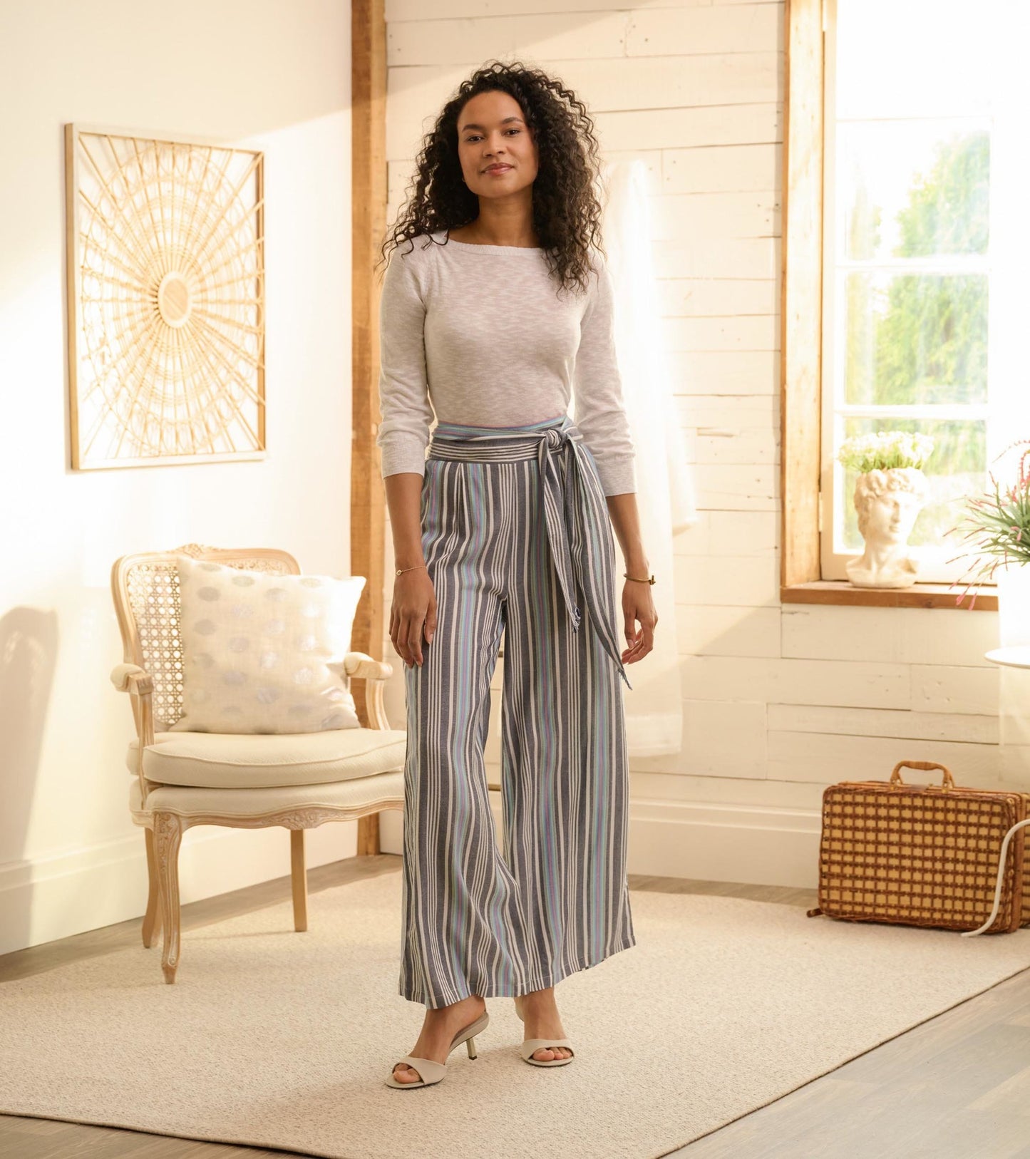 Belted wide leg pants featuring rainbow stripes, lightweight fabric, and a relaxed fit, styled with a casual top.