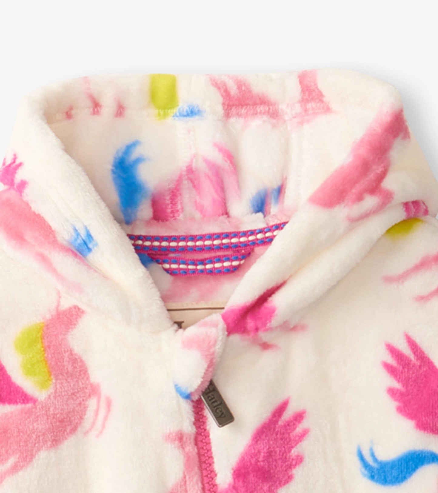 Soft fleece baby suit in cream with colorful unicorn and cloud patterns, featuring a hood and front zipper.