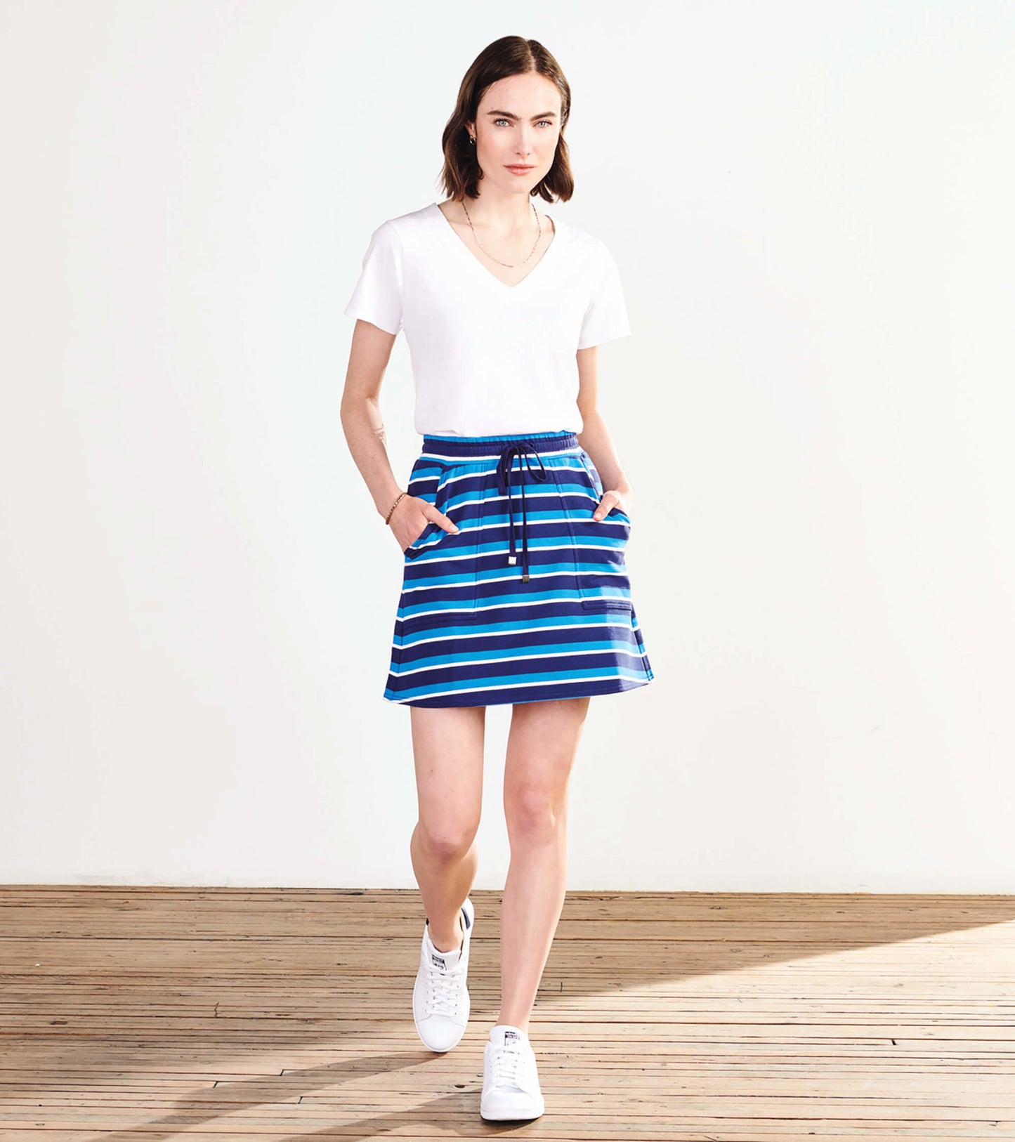 Striped skirt in deep blue with light blue and turquoise stripes, featuring a drawstring waist and side pockets.