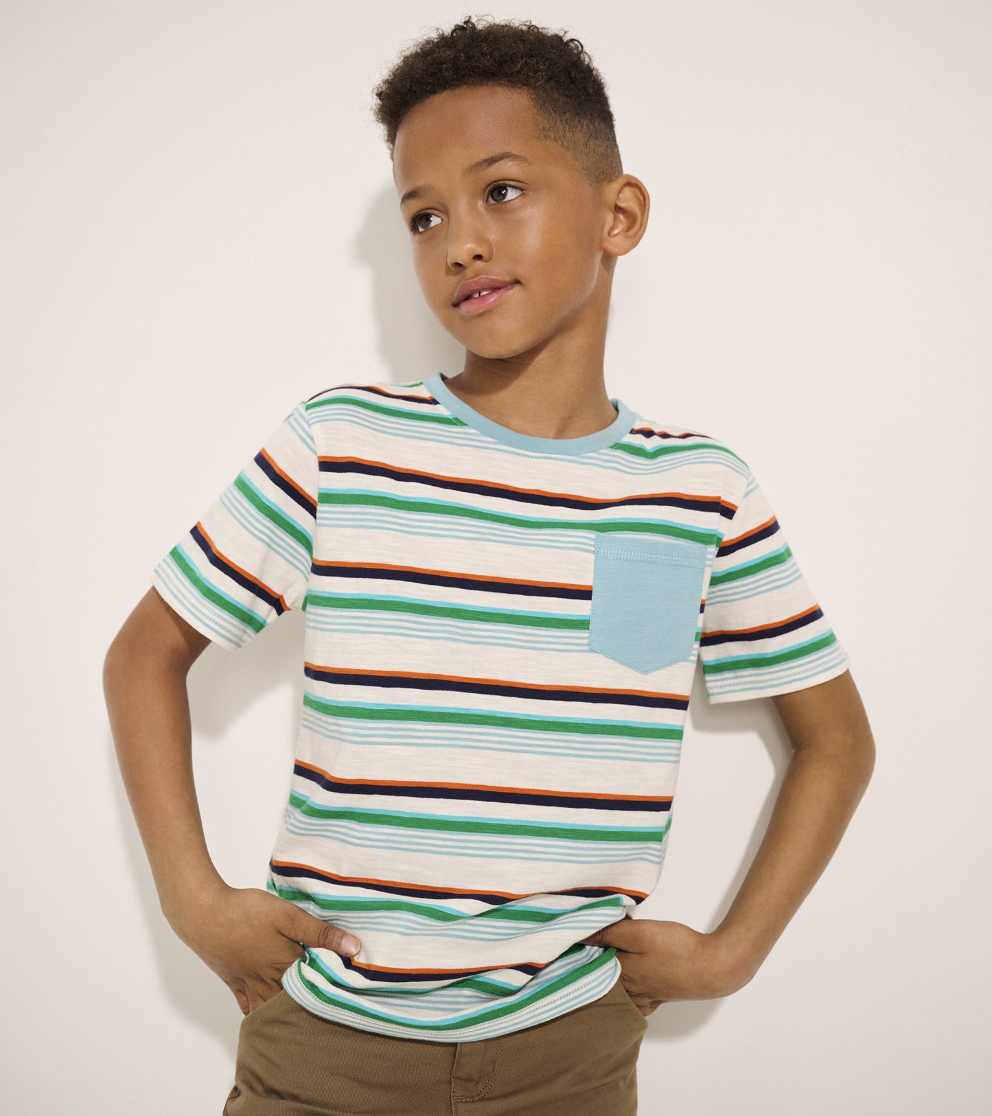 Striped short-sleeve tee featuring green, orange, and navy lines with a light blue pocket, perfect for casual wear.