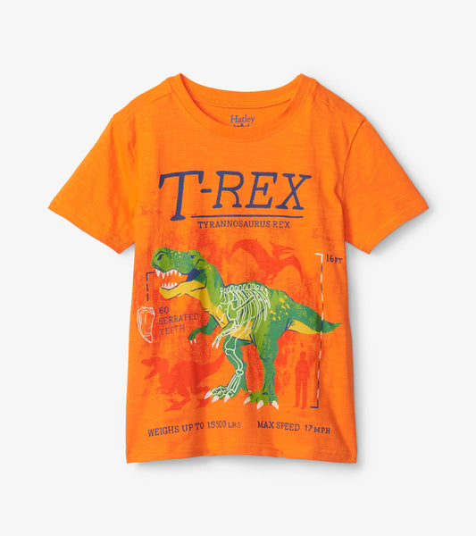 Orange short-sleeve tee featuring a glow-in-the-dark T-Rex graphic with text and dinosaur details.