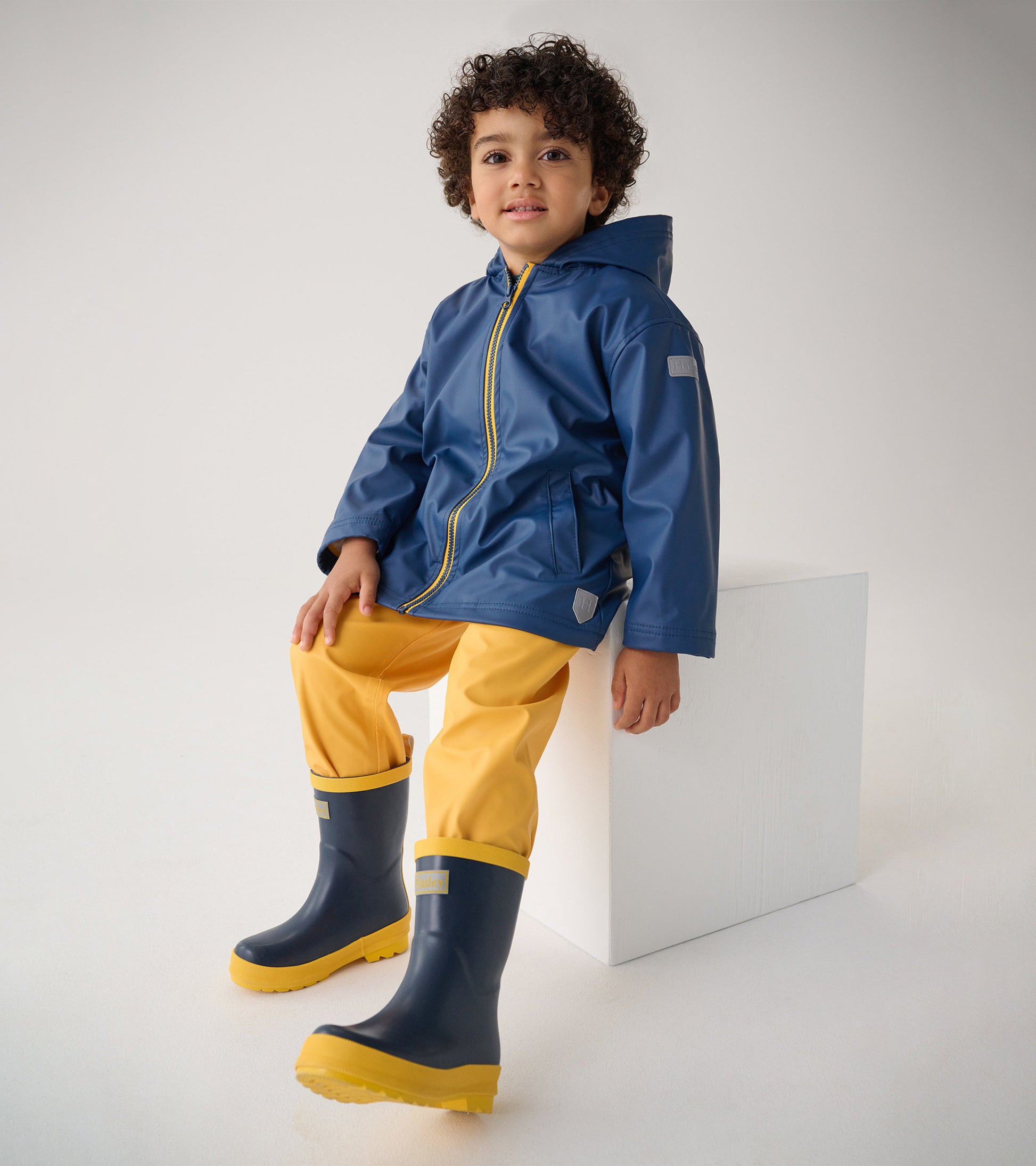Navy and yellow matte rain boots for kids, featuring a sturdy sole and a comfortable fit, ideal for wet weather.