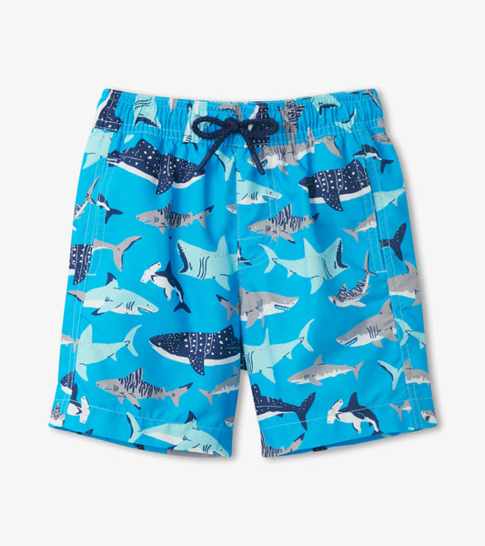 Blue swim trunks featuring a playful shark pattern in various shades, ideal for beach or pool activities.