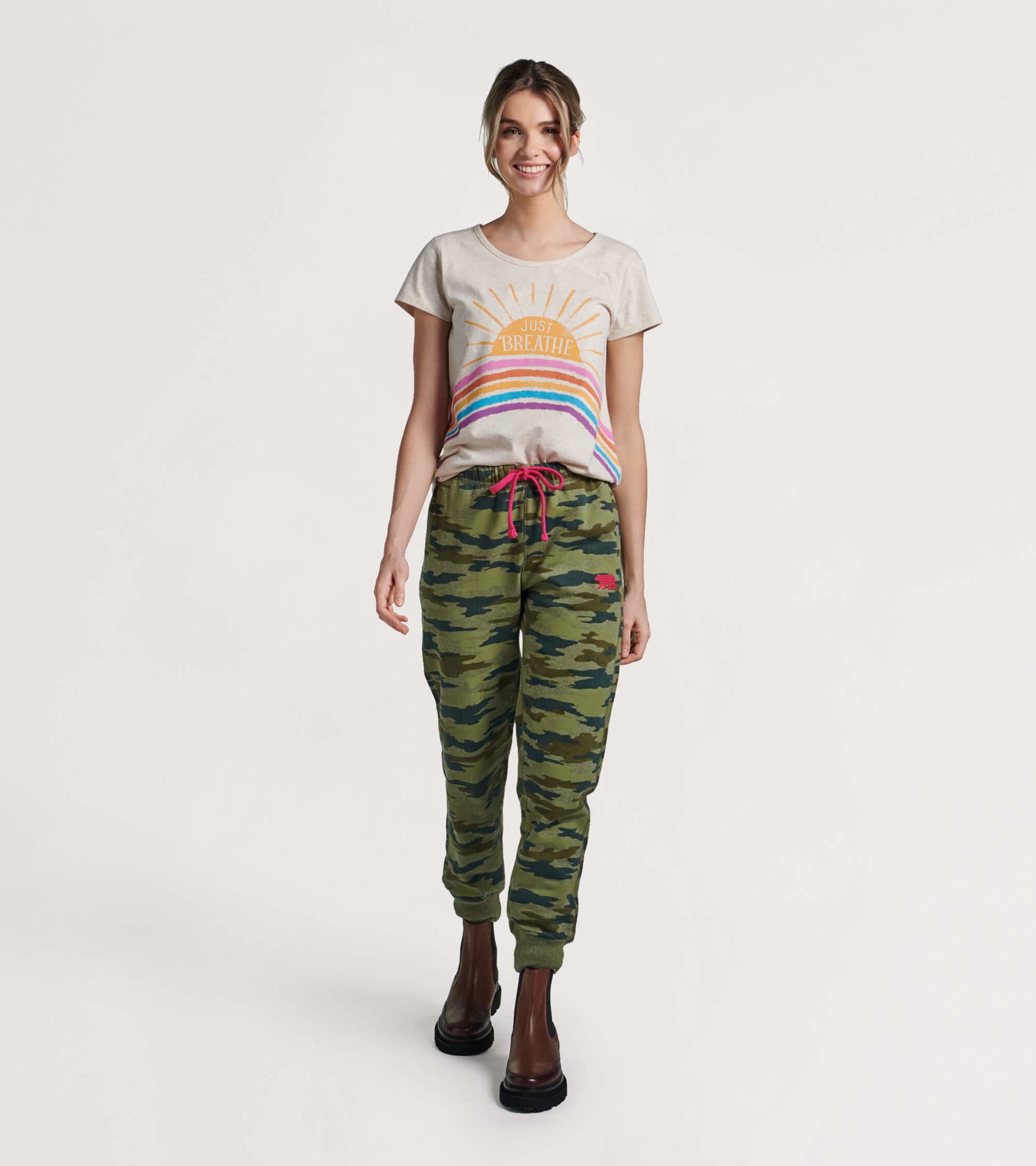 Green camouflage joggers with a drawstring waist, paired with a light gray graphic tee.
