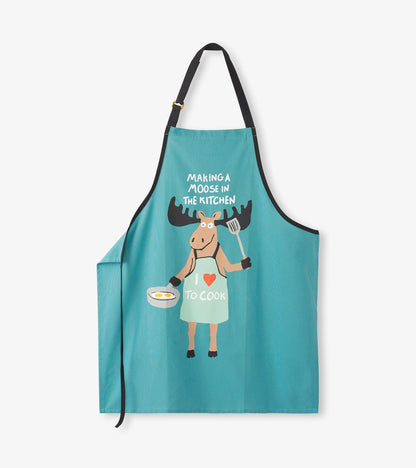 Teal kitchen apron with black straps and moose graphic holding a spatula and pan, front view