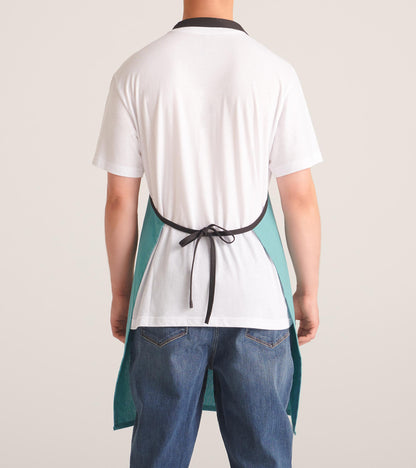 Back view of a white kitchen apron with teal side panels and black neck and waist ties, worn over a white shirt and jeans