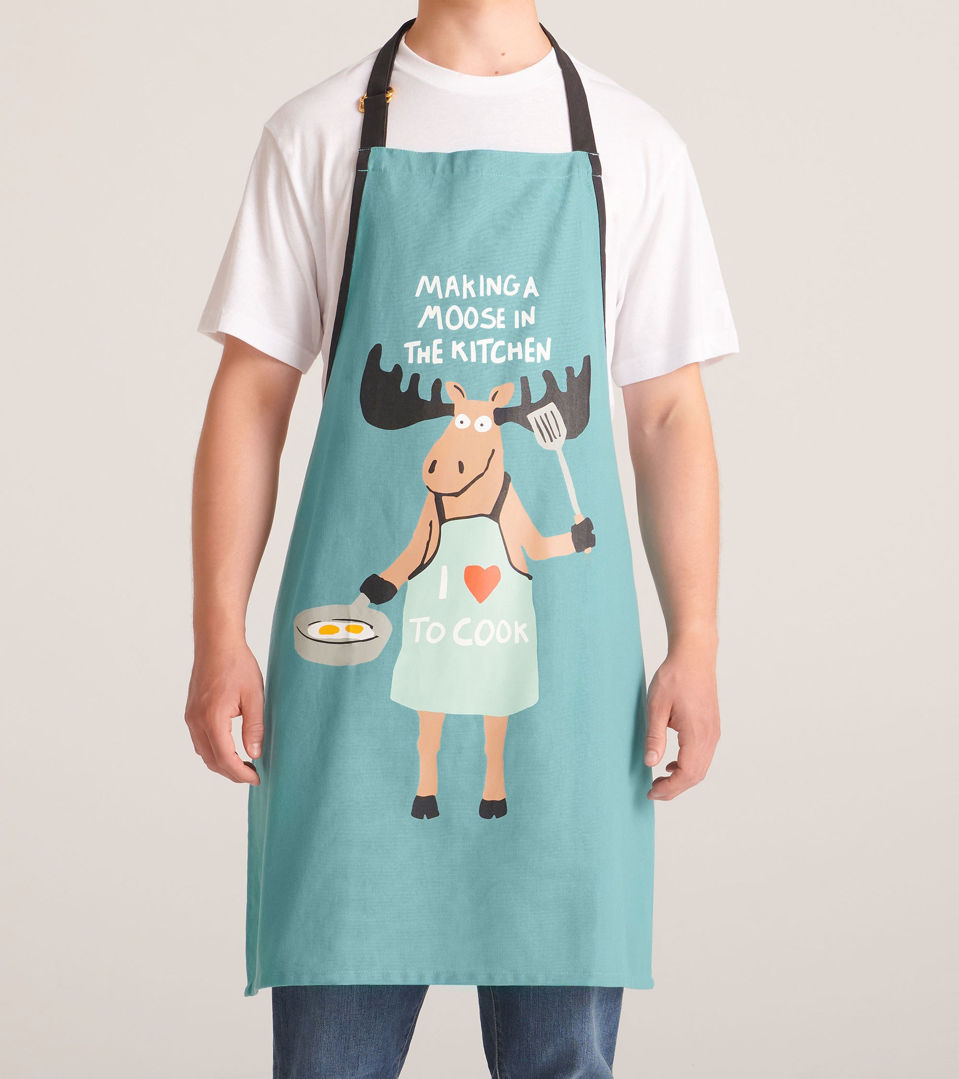 Teal kitchen apron with black straps and moose cooking graphic, worn front view