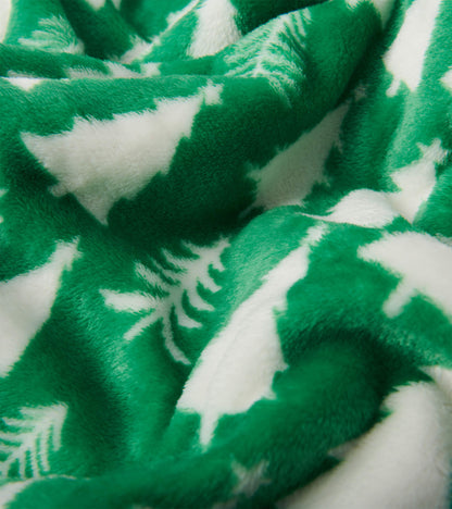 Close-up of green fuzzy fleece blanket with white Christmas tree pattern
